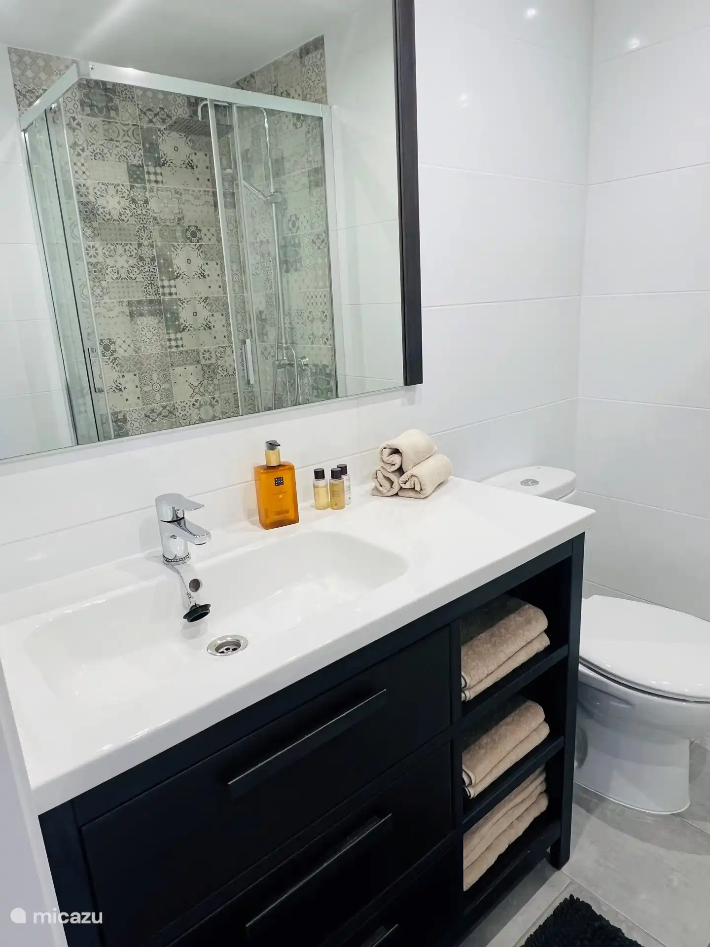 El baño 1, con lavabo, inodoro y ducha, pertenece al dormitorio 1.