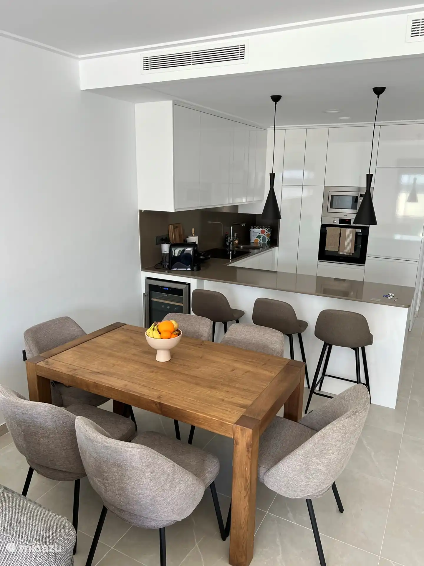 Küche mit Weinkühlschrank und Sitzgelegenheiten an der Theke