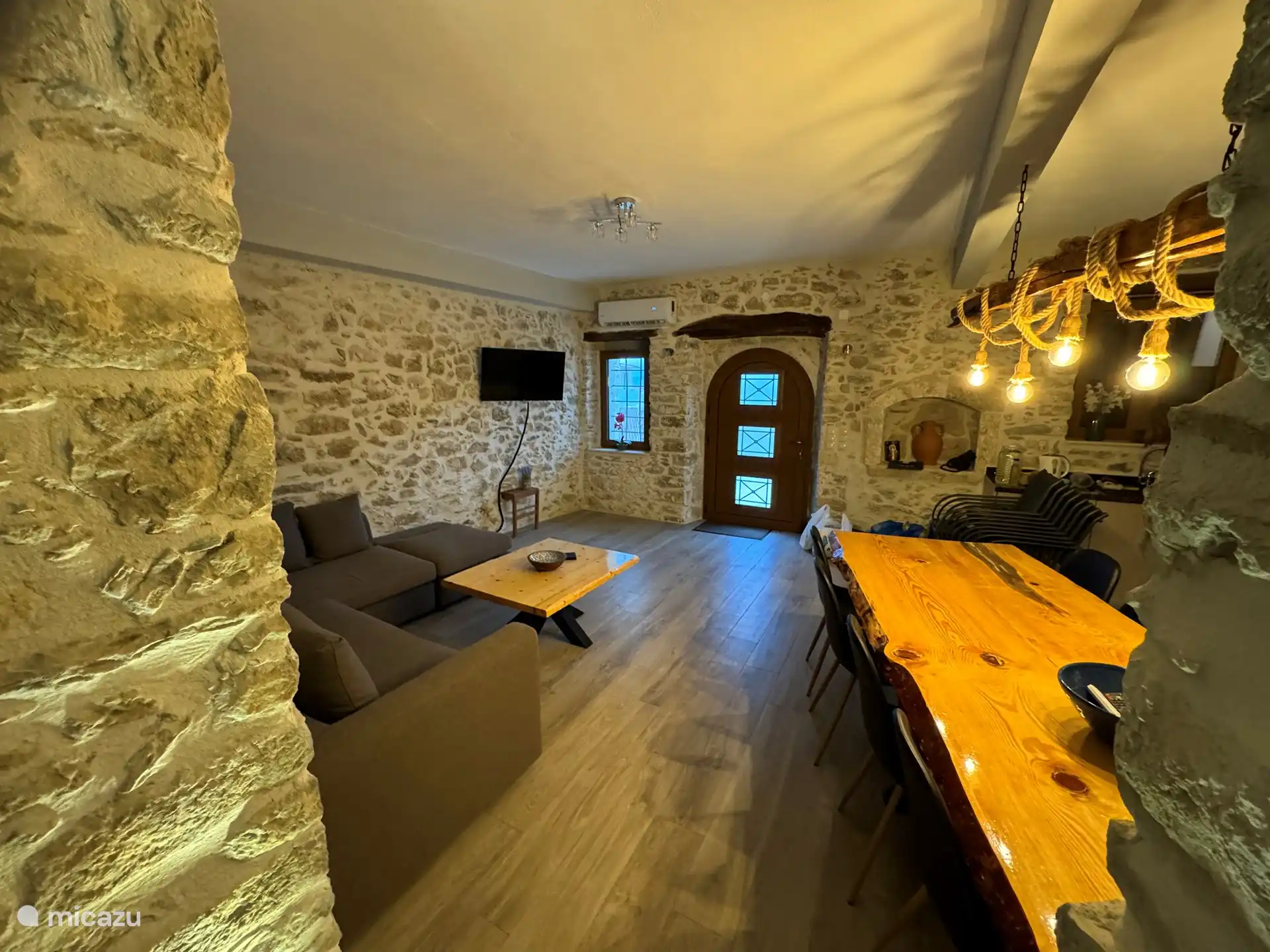 Geräumiges Wohnzimmer mit großem „Baumstamm“-Tisch (8 Personen) und voll ausgestatteter Küche.