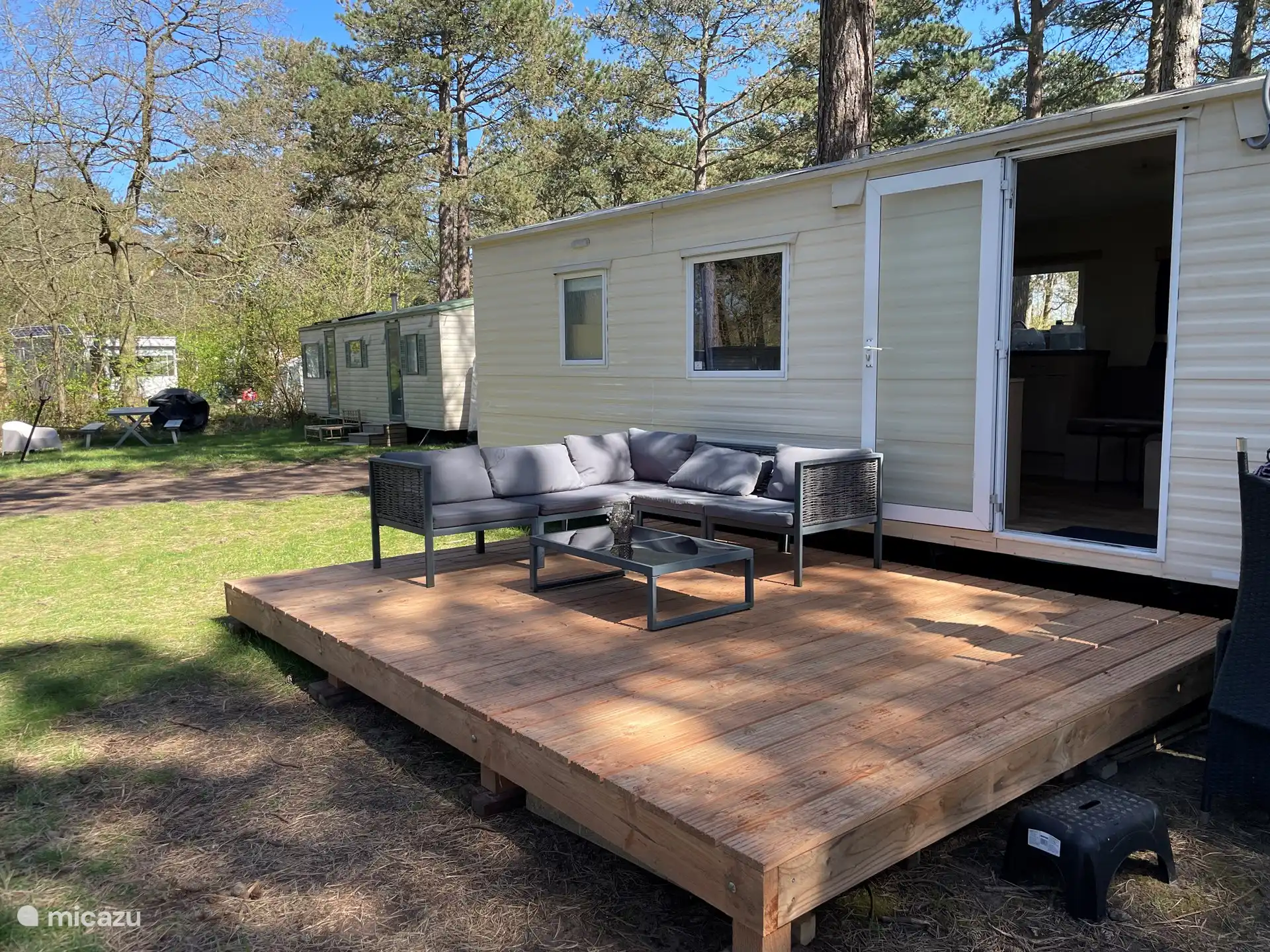 Belle terrasse en deck en bois avec salon de jardin.