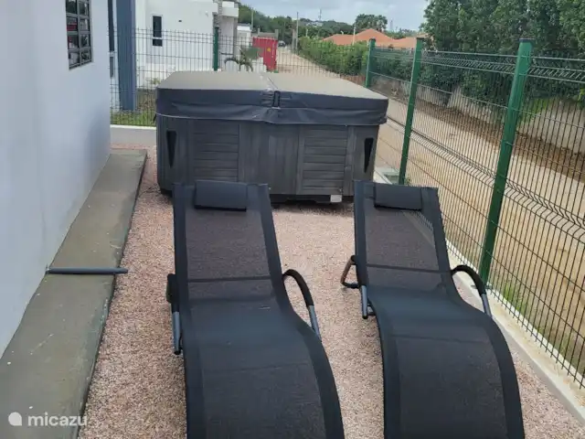 vakantiehuis huren in Curaçao, Banda Ariba (oost), Mambo Beach – Casa di Mambo Heerlijke ligstoelen in de zij-tuin. De afgrenzing is inmiddels bedekt voor je privacy.