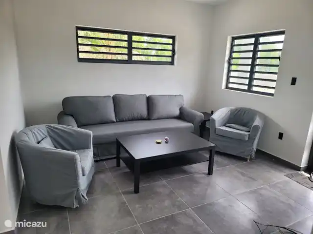 vakantiehuis huren in Curaçao, Banda Ariba (oost), Mambo Beach – Casa di Mambo Woonkamer met comfortabele stoelen en heerlijke lounchebank met er tegenover de televisie
