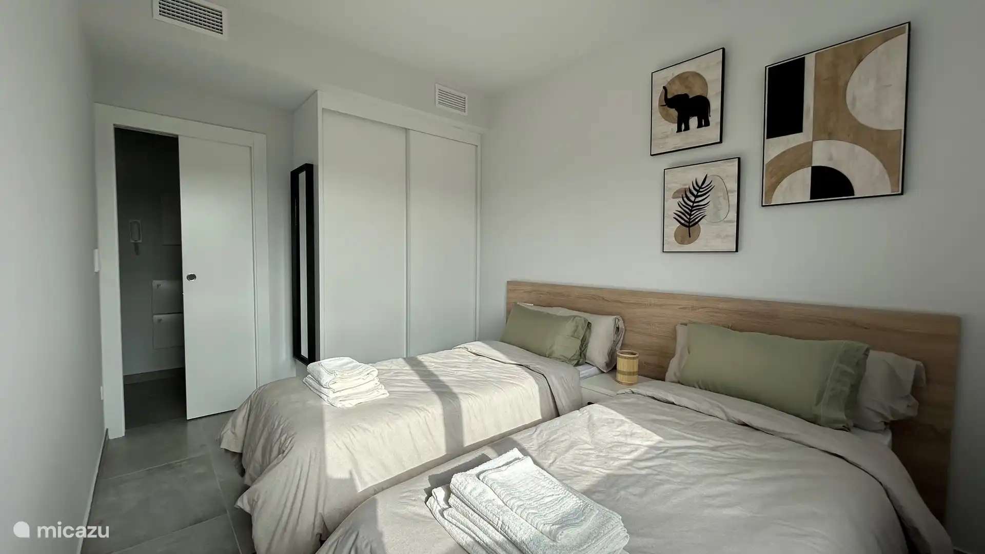 La chambre dispose d’une armoire spacieuse et d’un miroir en pied. 