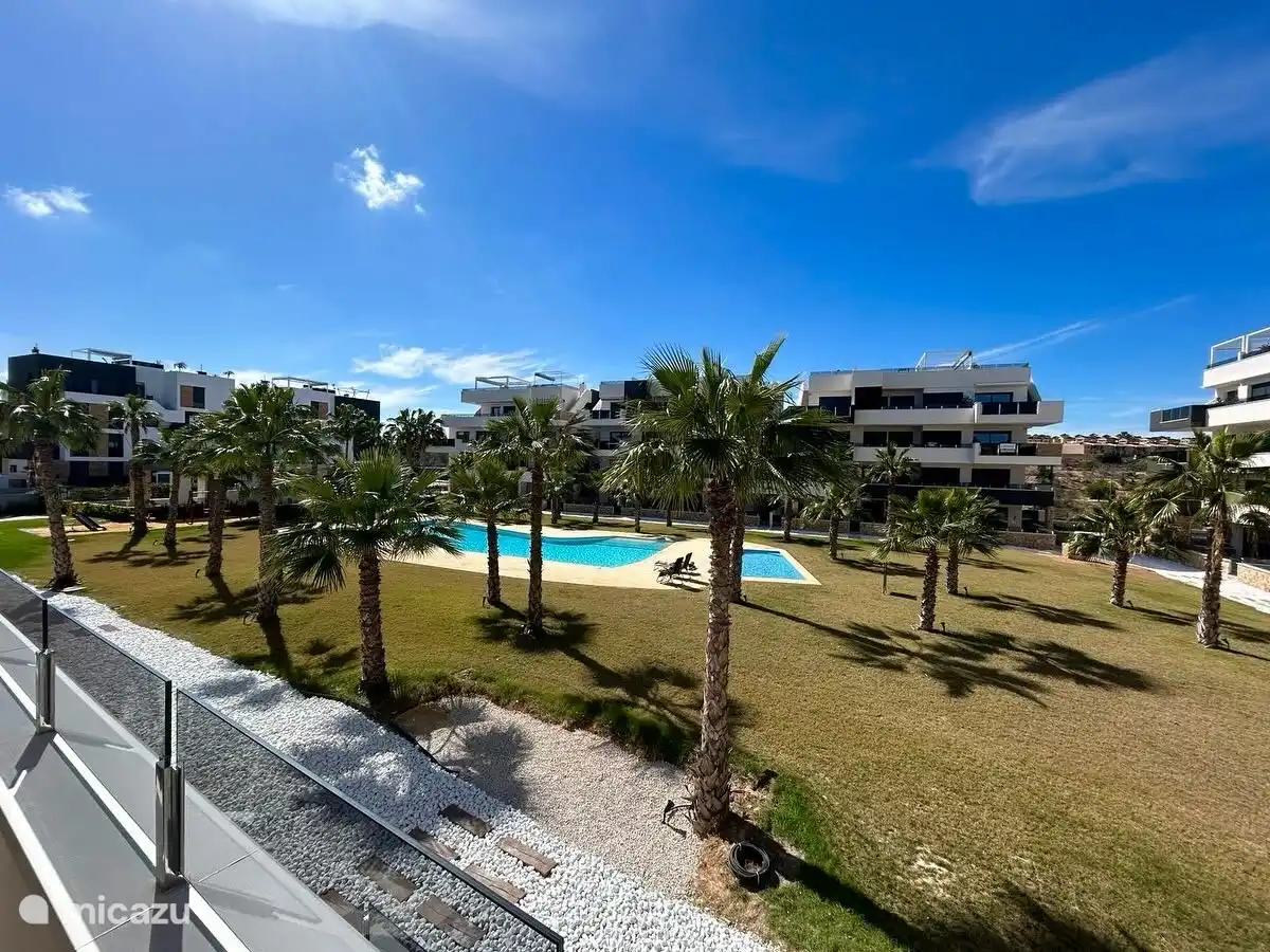 La vue de l’appartement sur le complexe d’appartements avec 2 piscines (dont 1 piscine pour enfants) et des douches extérieures. Tout autour, il y a beaucoup de possibilités de soleil sur la pelouse verte pour bronzer.