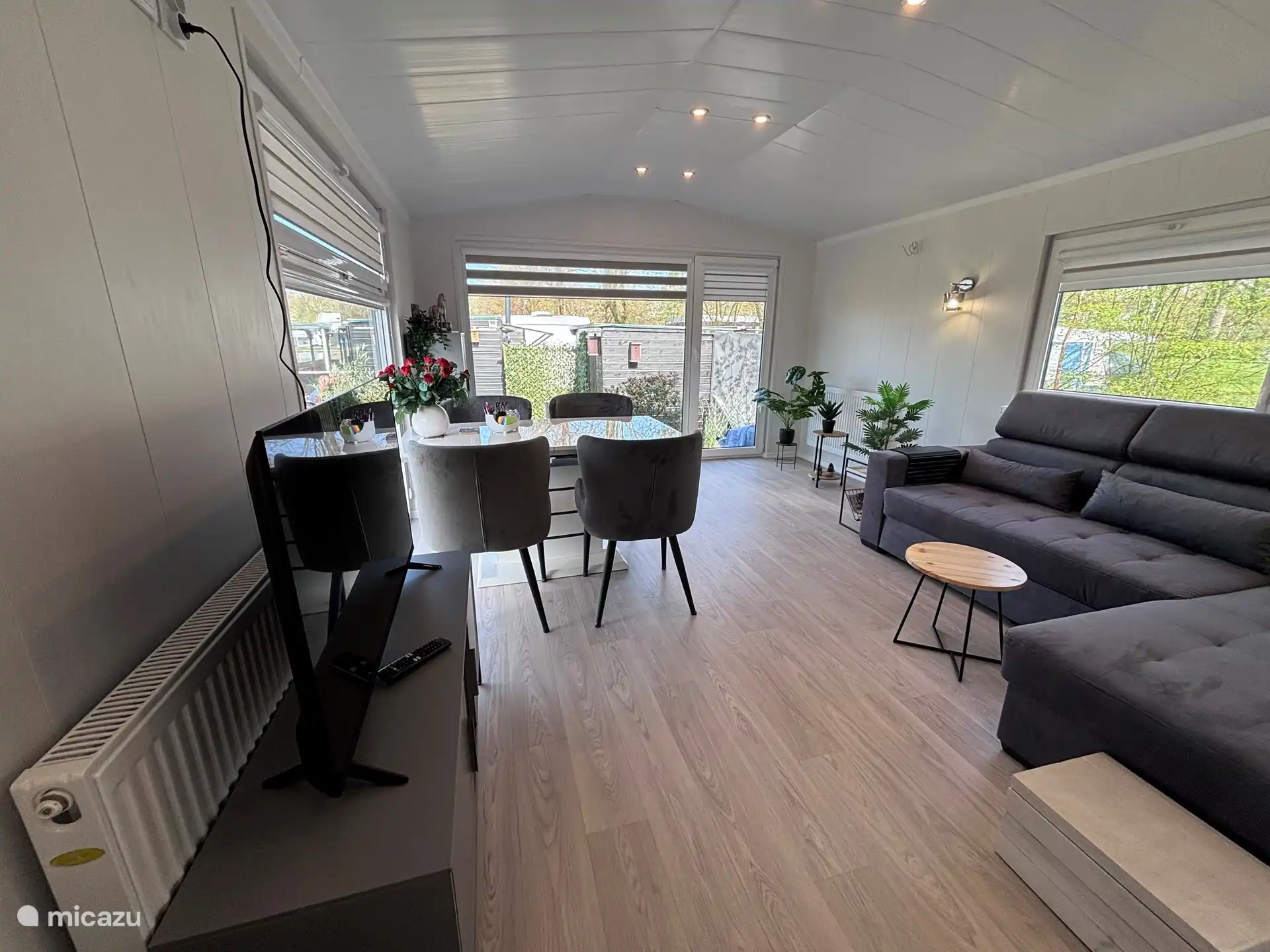 La amplia sala de estar tiene sofá y comedor con 4 sillas