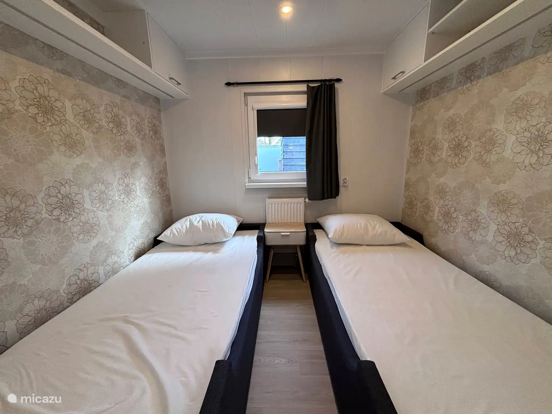 Dormitorio con cama para 2x1 personas de 80x200 con mosquitera frente a la ventana.