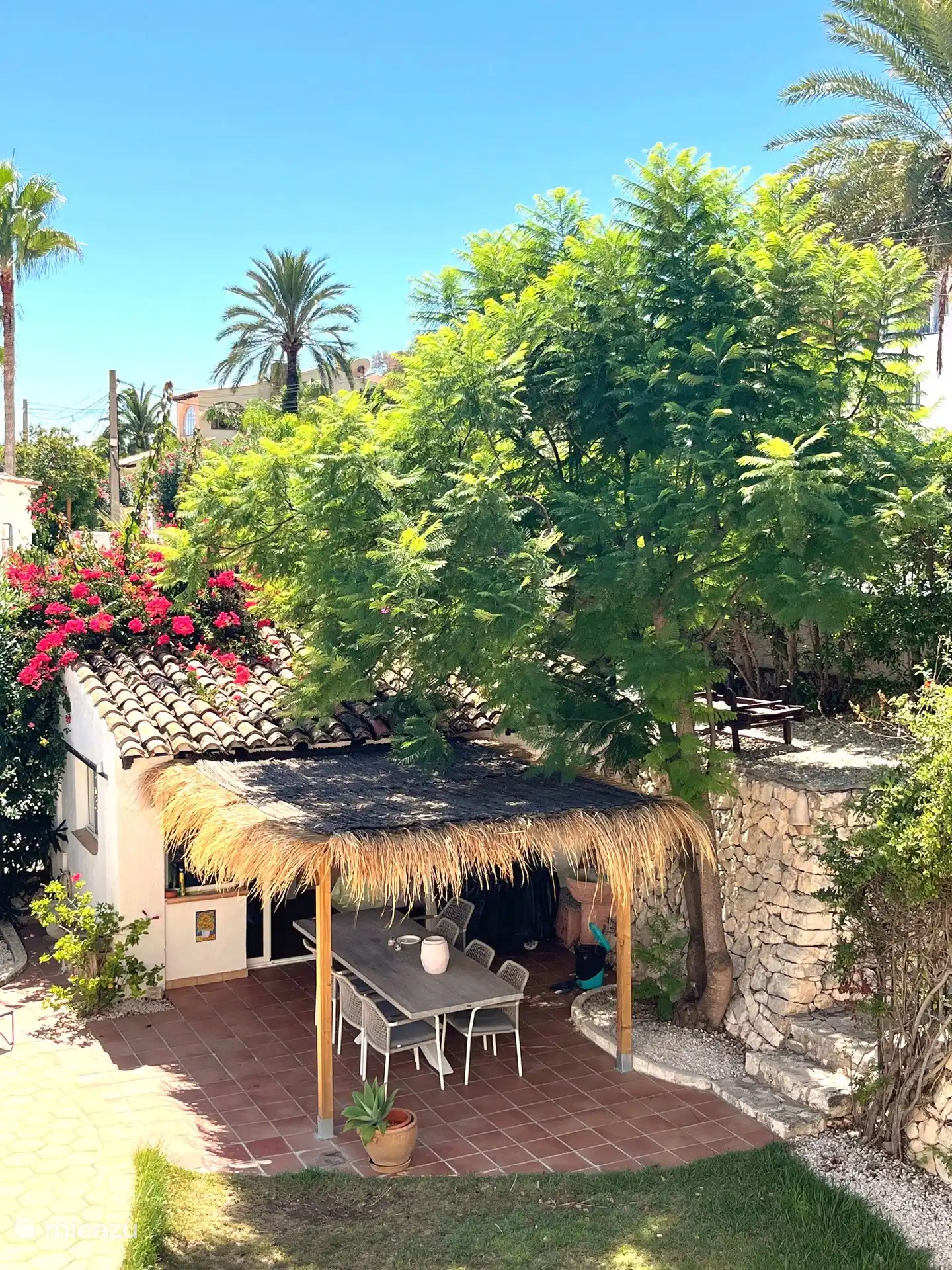 Bajo la pérgola, frente a la cocina exterior y junto a la piscina y el césped, es maravilloso comer juntos. 
