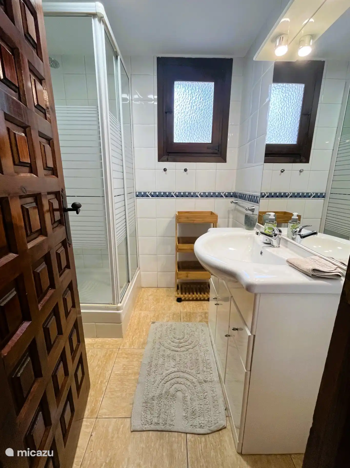 El segundo baño de la planta baja está al lado de un dormitorio y tiene ducha, inodoro y lavabo con mueble de lavabo y secador de pelo