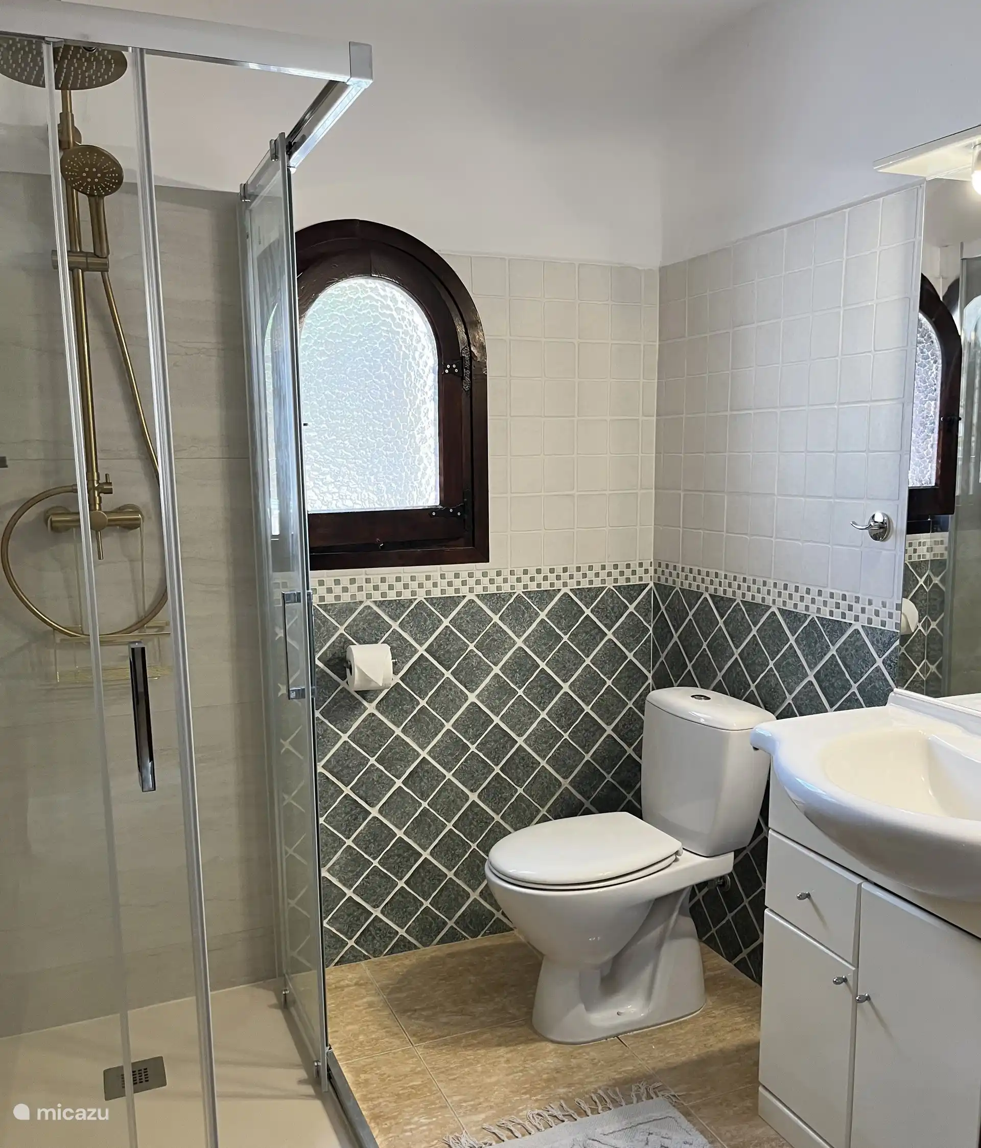 El baño más grande de abajo con un cubículo de ducha nuevo con ducha de lluvia.