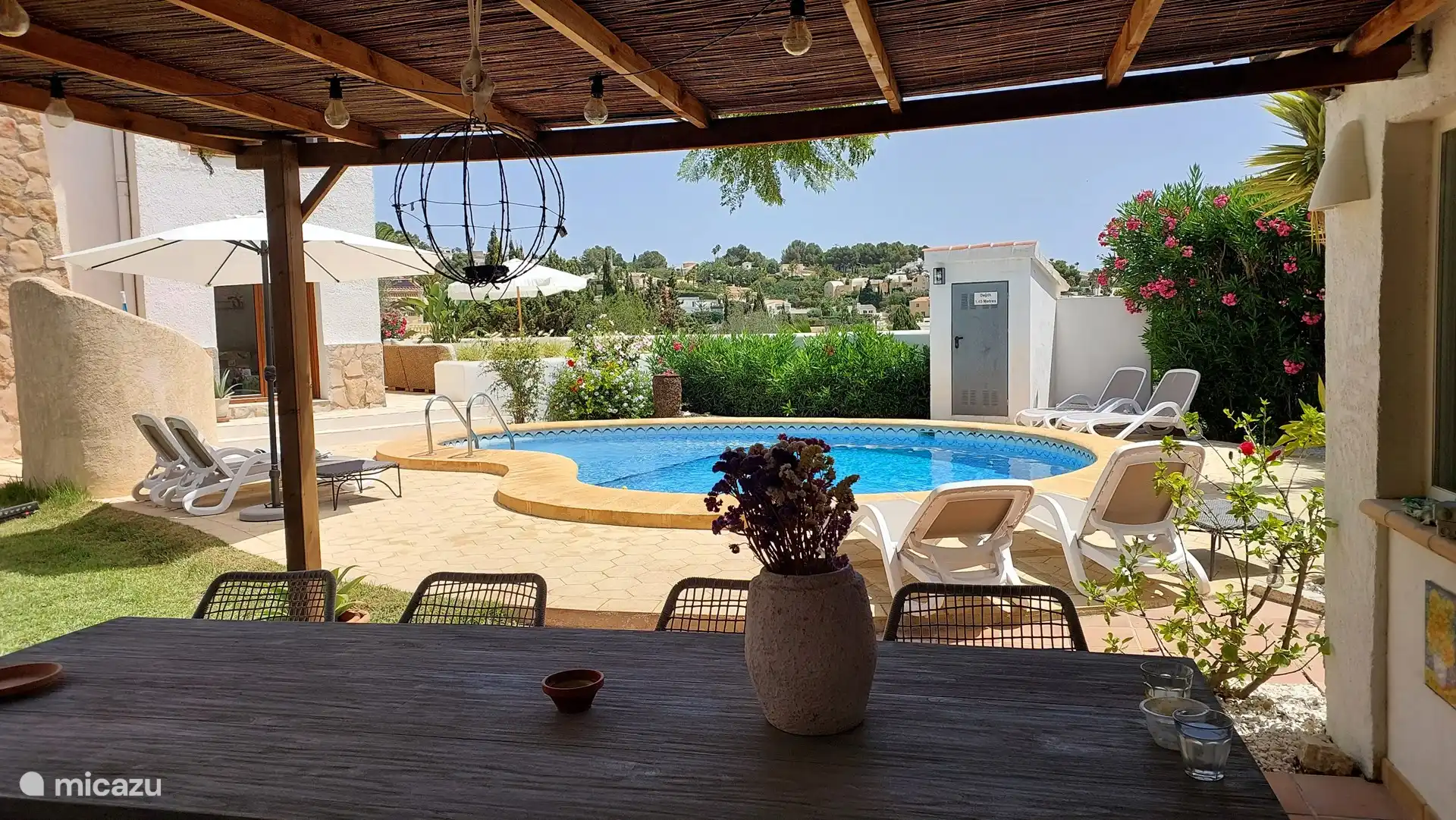 Bajo la pérgola, frente a la cocina al aire libre, es encantador a la sombra cuando el sol está más caliente. Por la noche también se puede cenar bajo la pérgola con techo de paja con una iluminación acogedora.