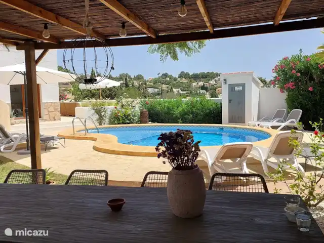 Villa Salvia en España, Costa Blanca, Benissa - villa Bajo la pérgola, frente a la cocina al aire libre, es encantador a la sombra cuando el sol está más caliente. Por la noche también se puede cenar bajo la pérgola con techo de paja con una iluminación acogedora.