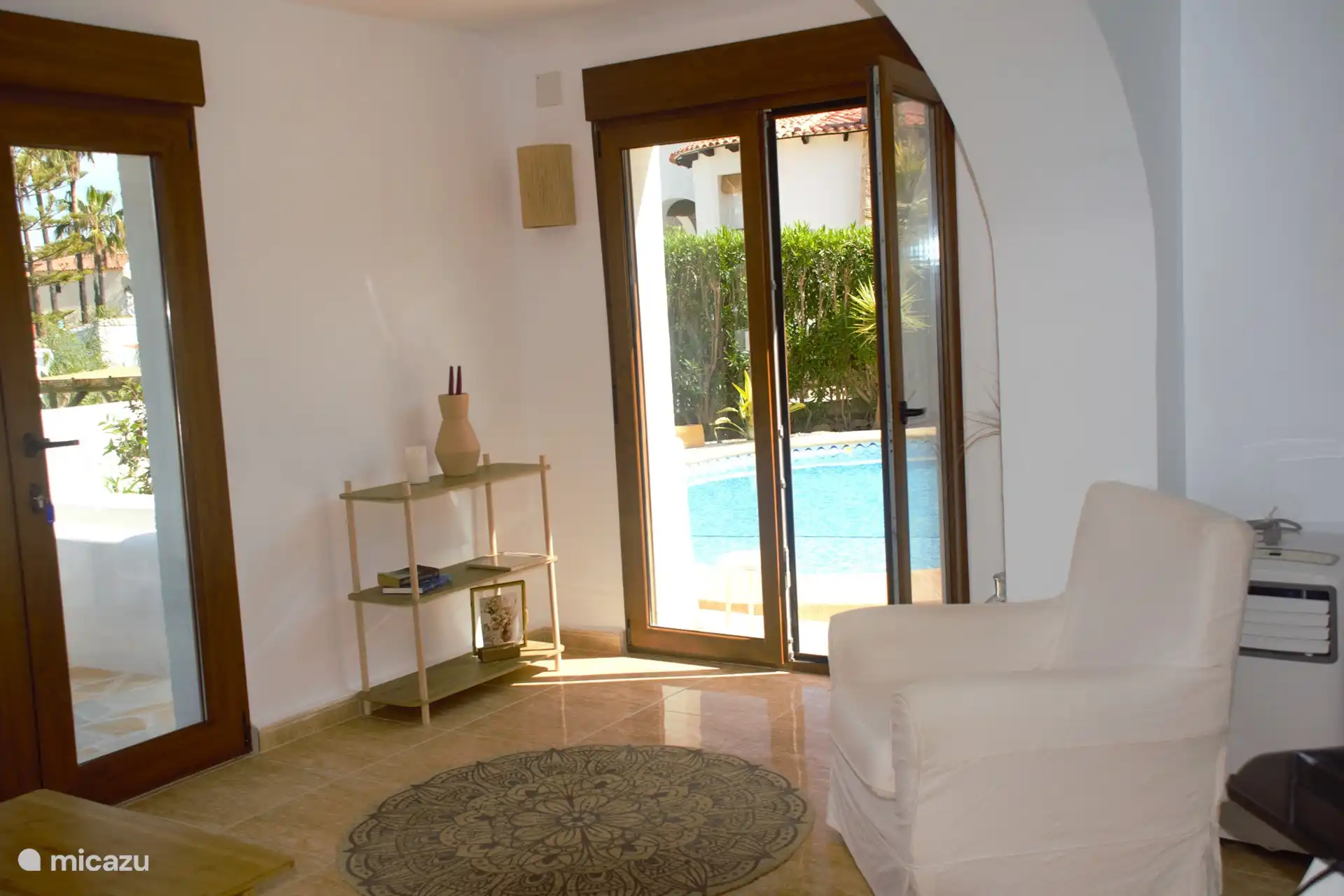 Desde la planta baja se puede pasar por las puertas del patio a la piscina o a la terraza con sofá lounge y sofá enlucido.