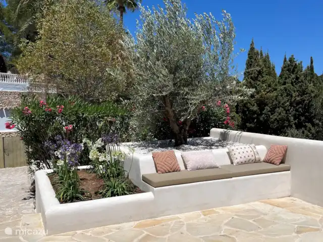 Villa Salvia en España, Costa Blanca, Benissa - villa En el banco de estuco se puede disfrutar de la vista entre las flores y las plantas.
Las nuevas jardineras están llenas de un viejo olivo y flores y plantas que ondean con la brisa.
