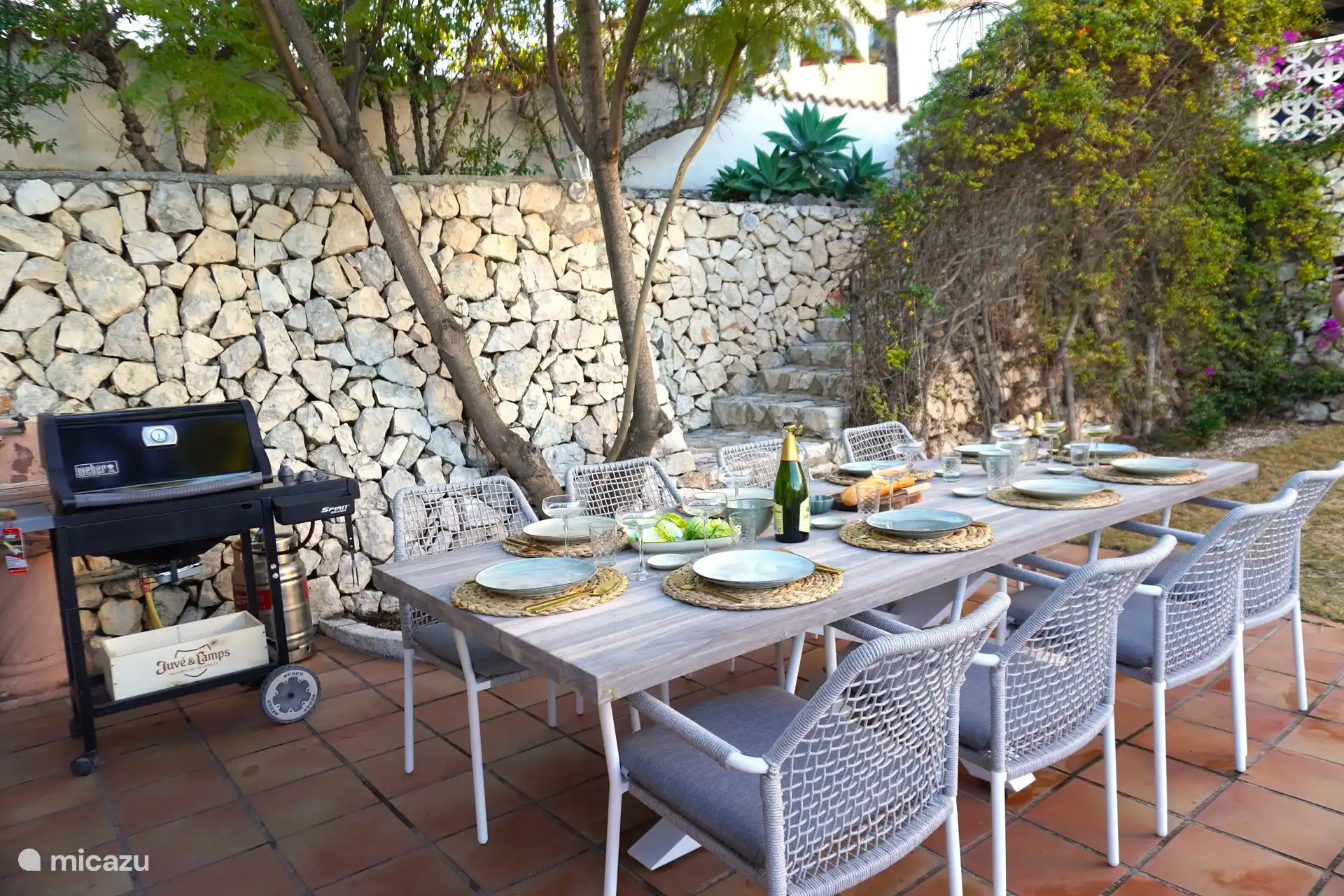 Acogedora barbacoa y cena juntos en el jardín, frente a la cocina exterior bajo la pérgola.
