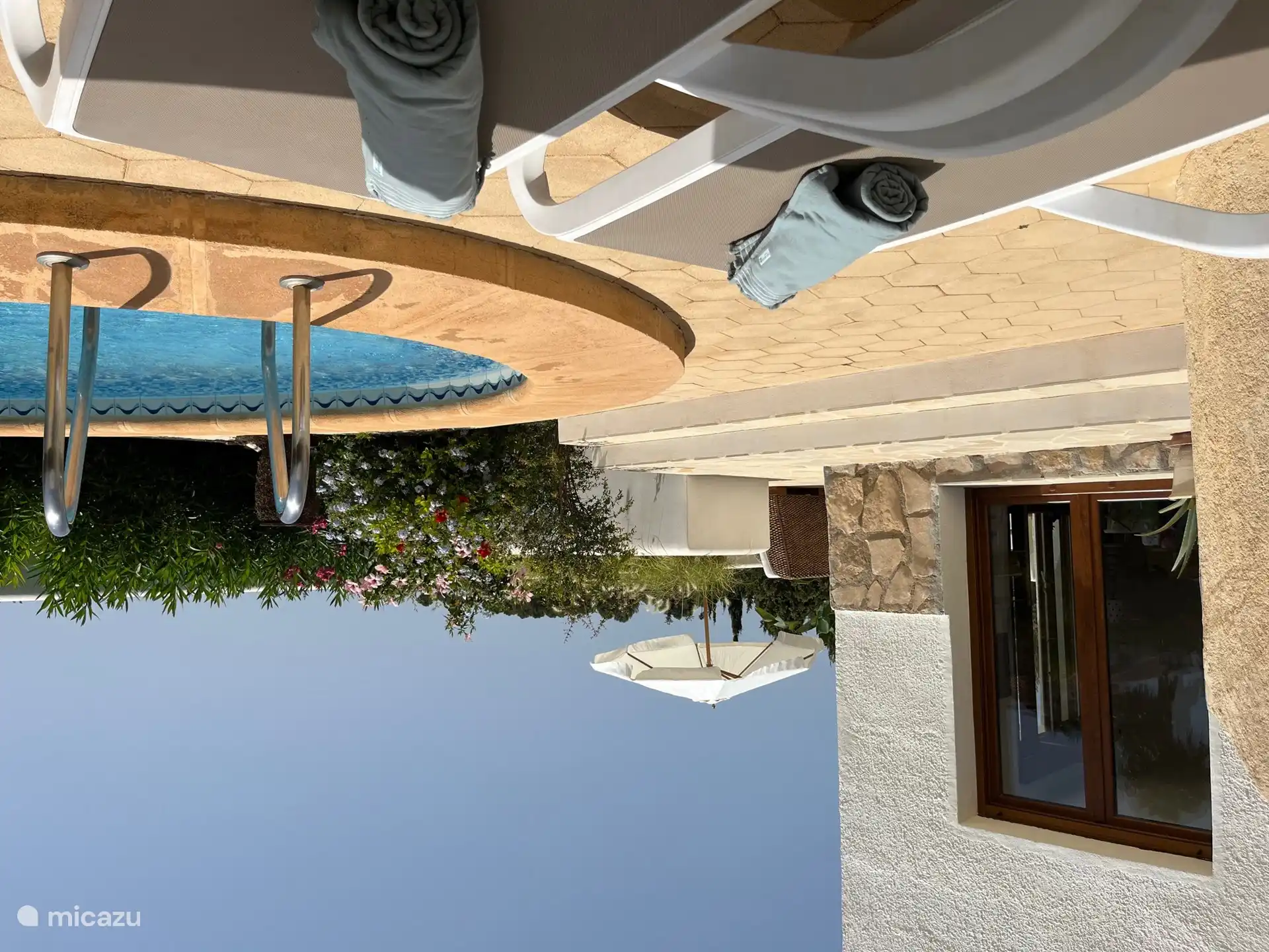 A través de puertas francesas en la planta baja se llega a la terraza más grande con sofá y hermosas vistas del valle y la piscina. 
