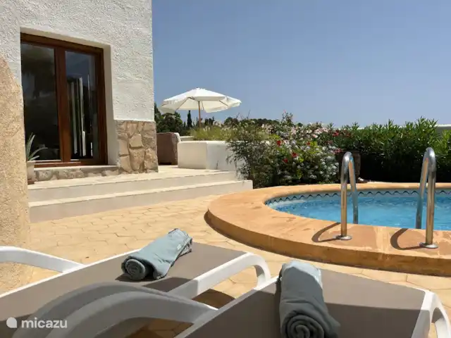 Villa Salvia en España, Costa Blanca, Benissa - villa A través de puertas francesas en la planta baja se llega a la terraza más grande con sofá y hermosas vistas del valle y la piscina.