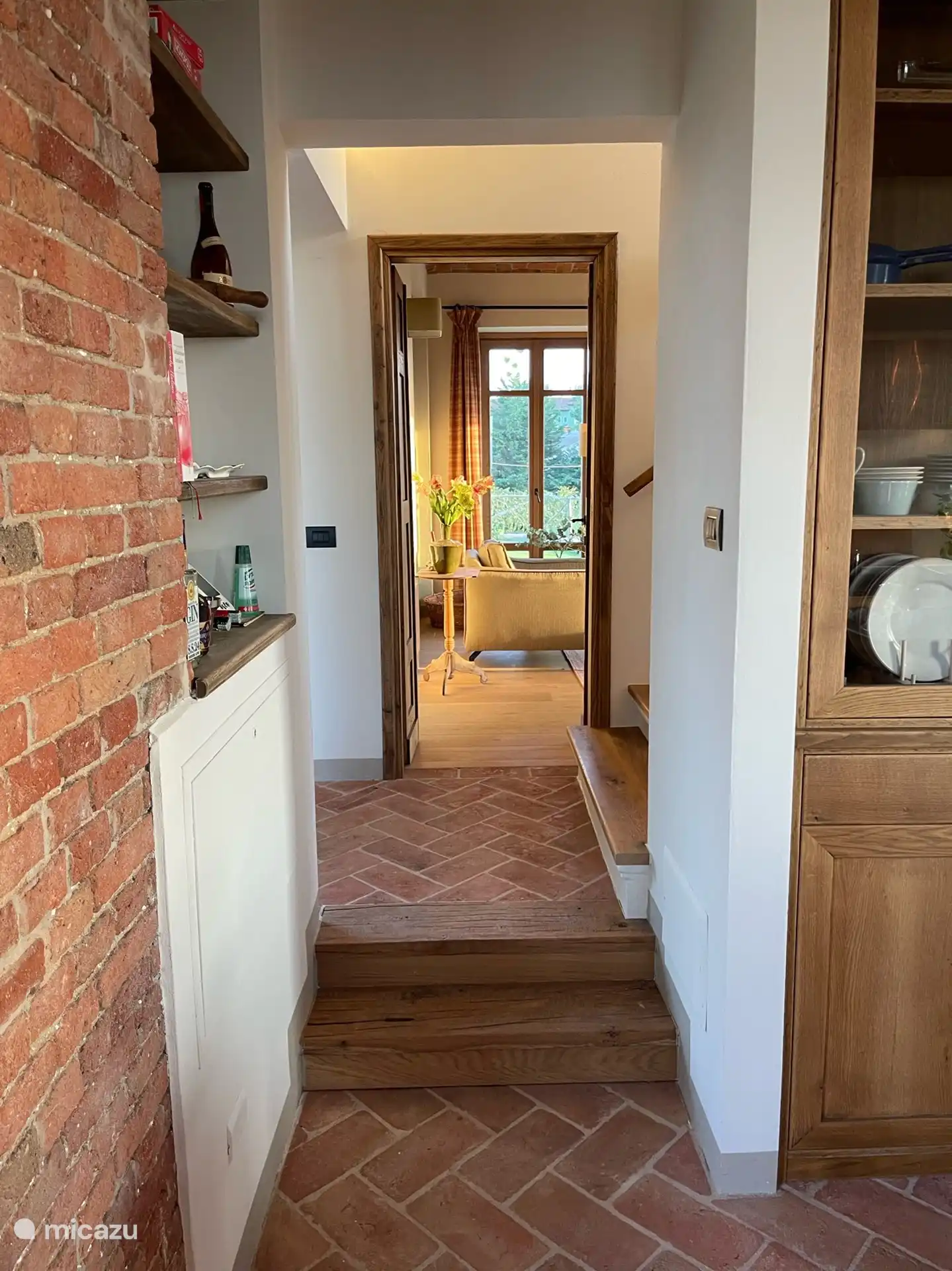 Doorgang van keuken naar de woonkamer met in het midden de trap naar de 1e verdieping. 