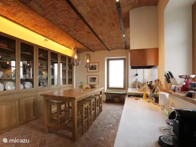 Casa Rinaldi  | Italie, Piémont, Monforte D Alba - maison de vacances Cuisine avec une table de bar spacieuse, un grand comptoir en marbre et un grand placard avec vaisselle.