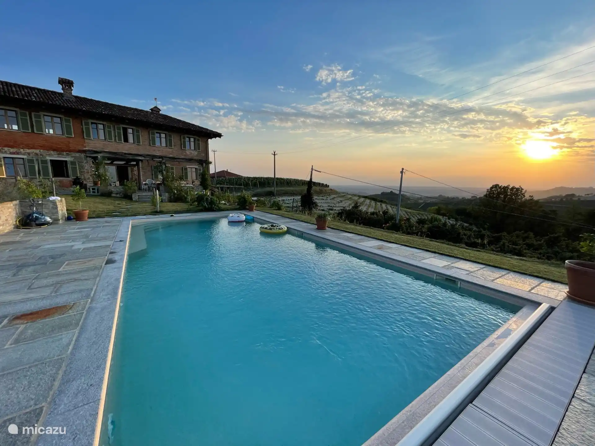 Zwembad uitzicht op de achterkant van het huis met terras. 