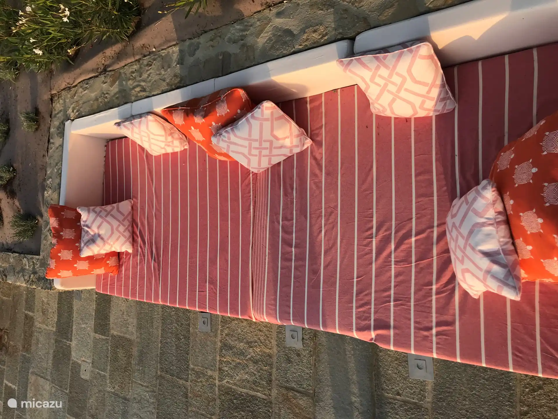 Ruime loungebank van 4 meter breed en 2,5 meter diep. Deze bank ligt de hele dag in de volle zon. Hier kijk je prachtig uit over de wijngaarden met op de achtergrond de bergen. 