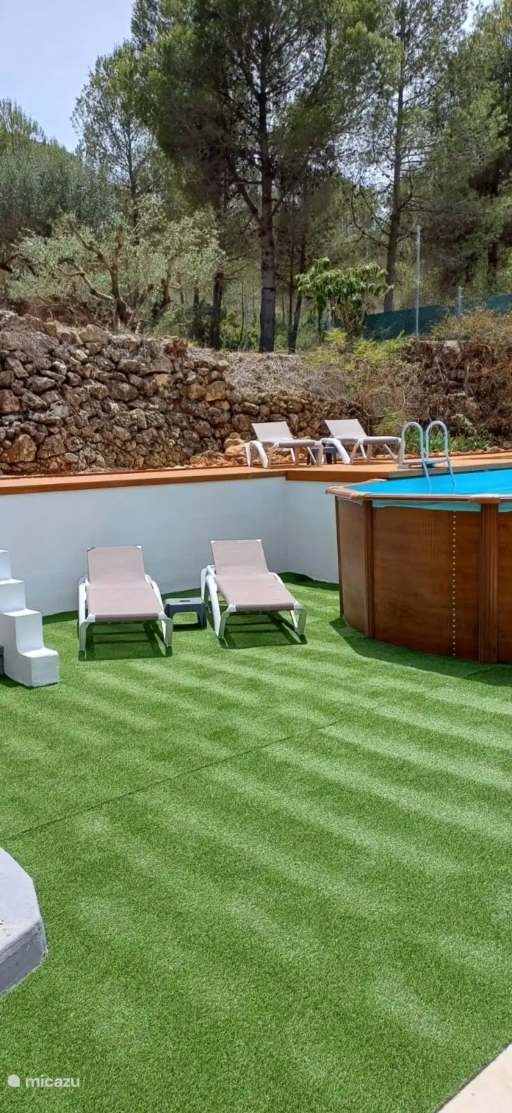 Liegestühle rund um den Pool und auch schöner weicher Kunstrasen.