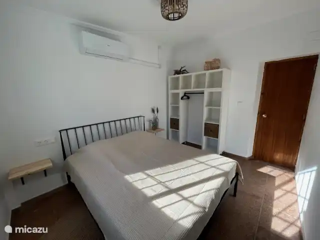 Villa Morera en España, Valencia, Albaida - villa El dormitorio más grande con cama de matrimonio, mesitas de noche y un amplio armario. Equipado con persianas, rejas, mosquitera y aire acondicionado.