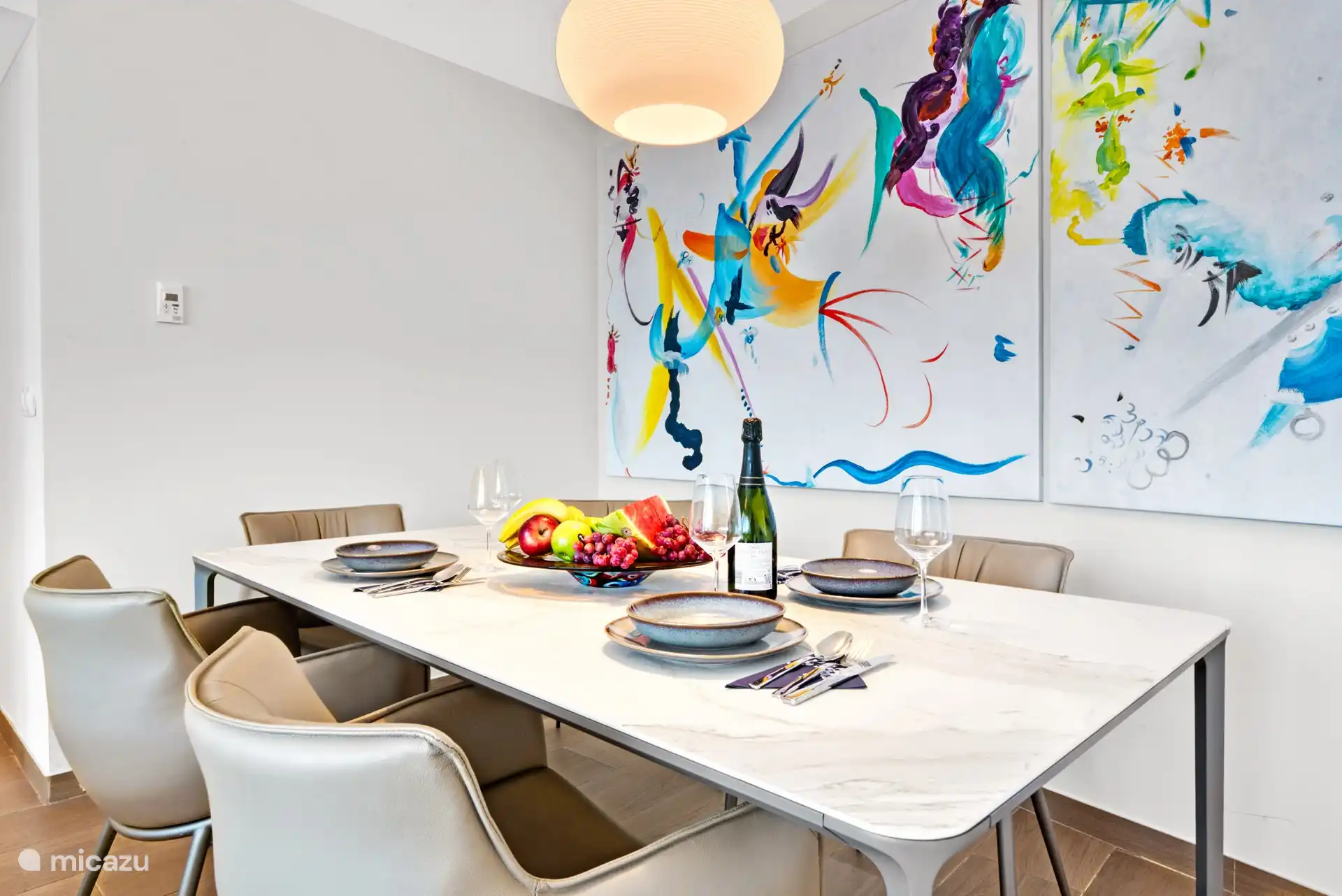 dining room table with paintings and Philips Hue lamp.