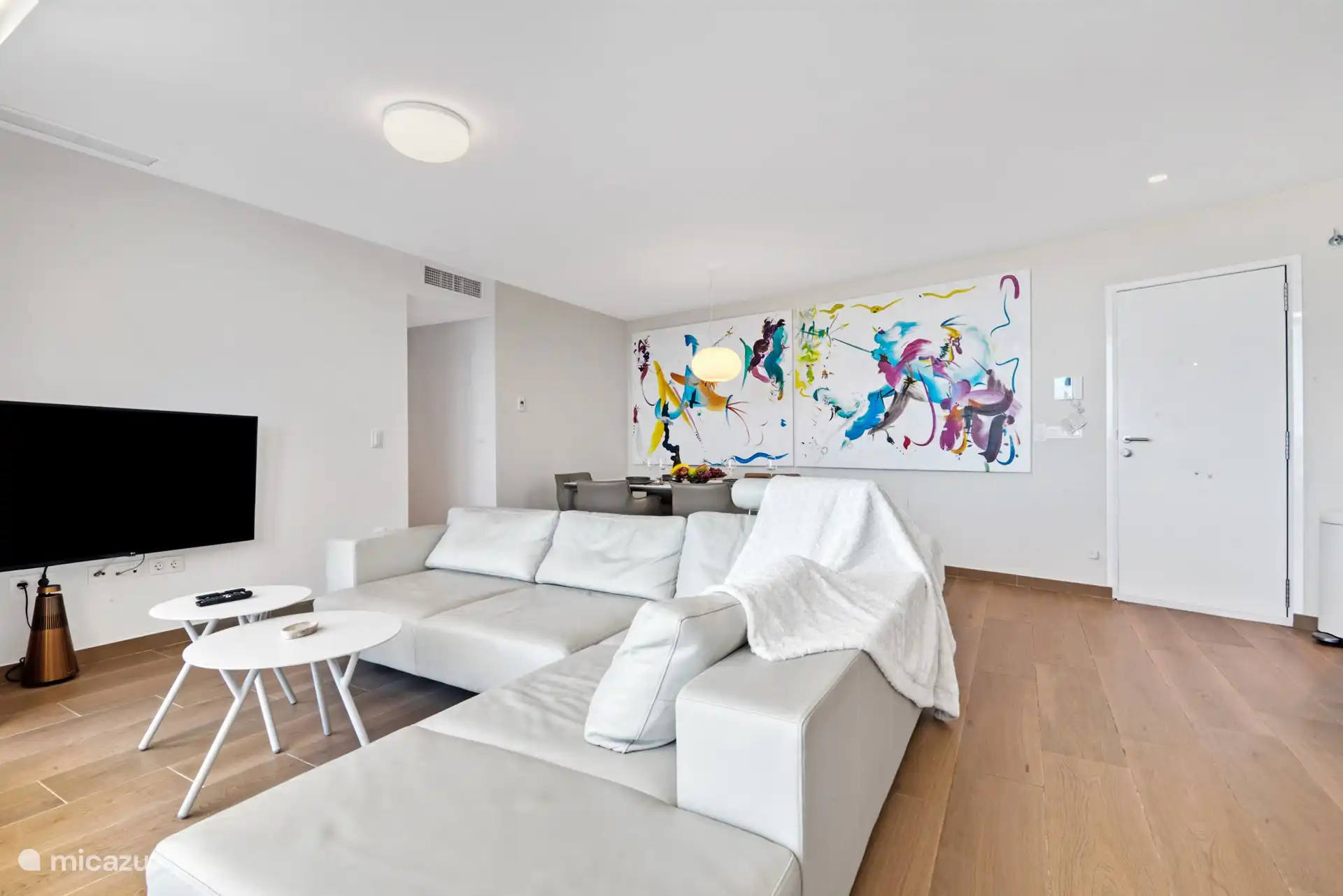 perspective from the corner of the living room and terrace to the sofa and dining room table. With a view of the hallway to the bedrooms.