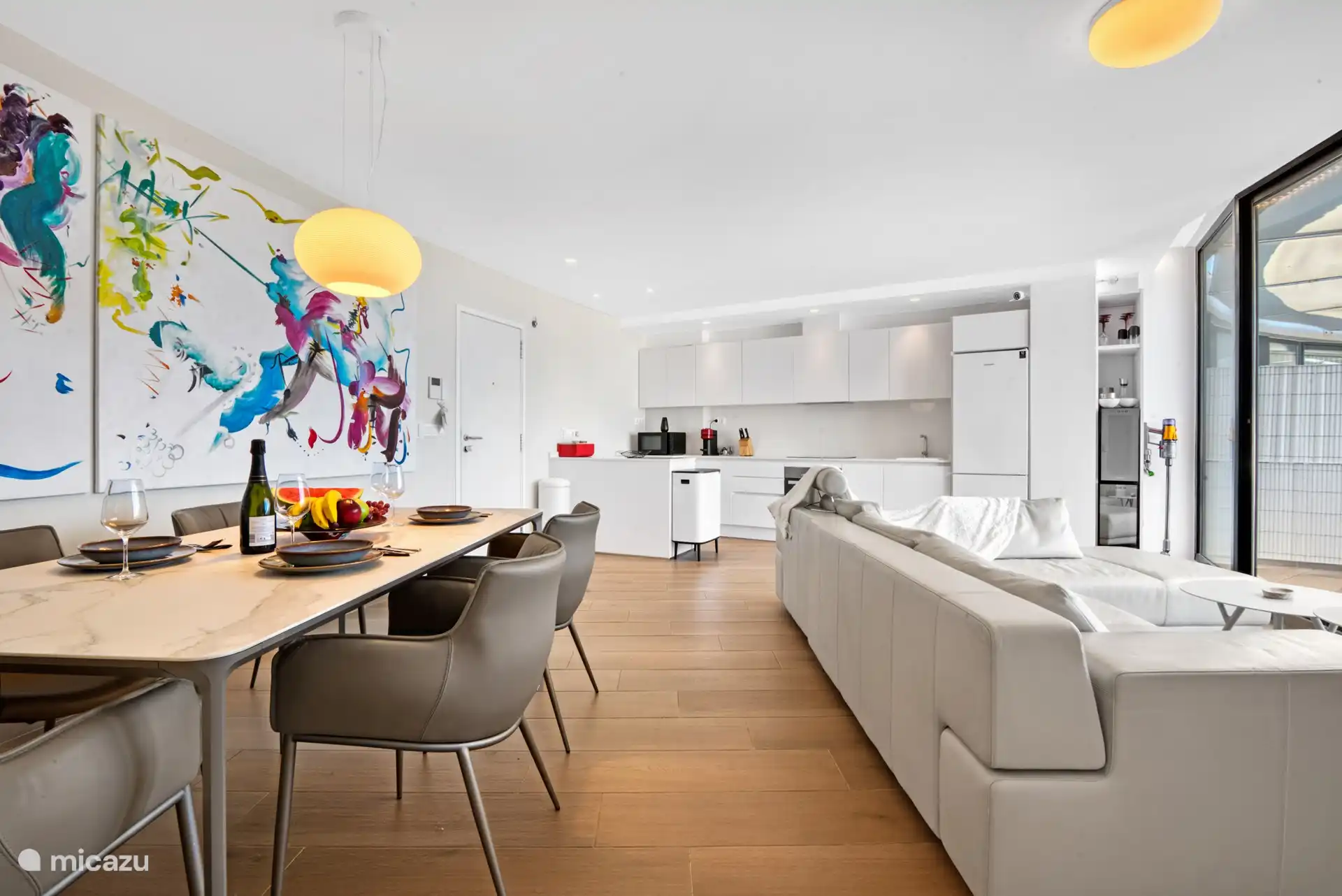 living room with kitchen with lots of light.