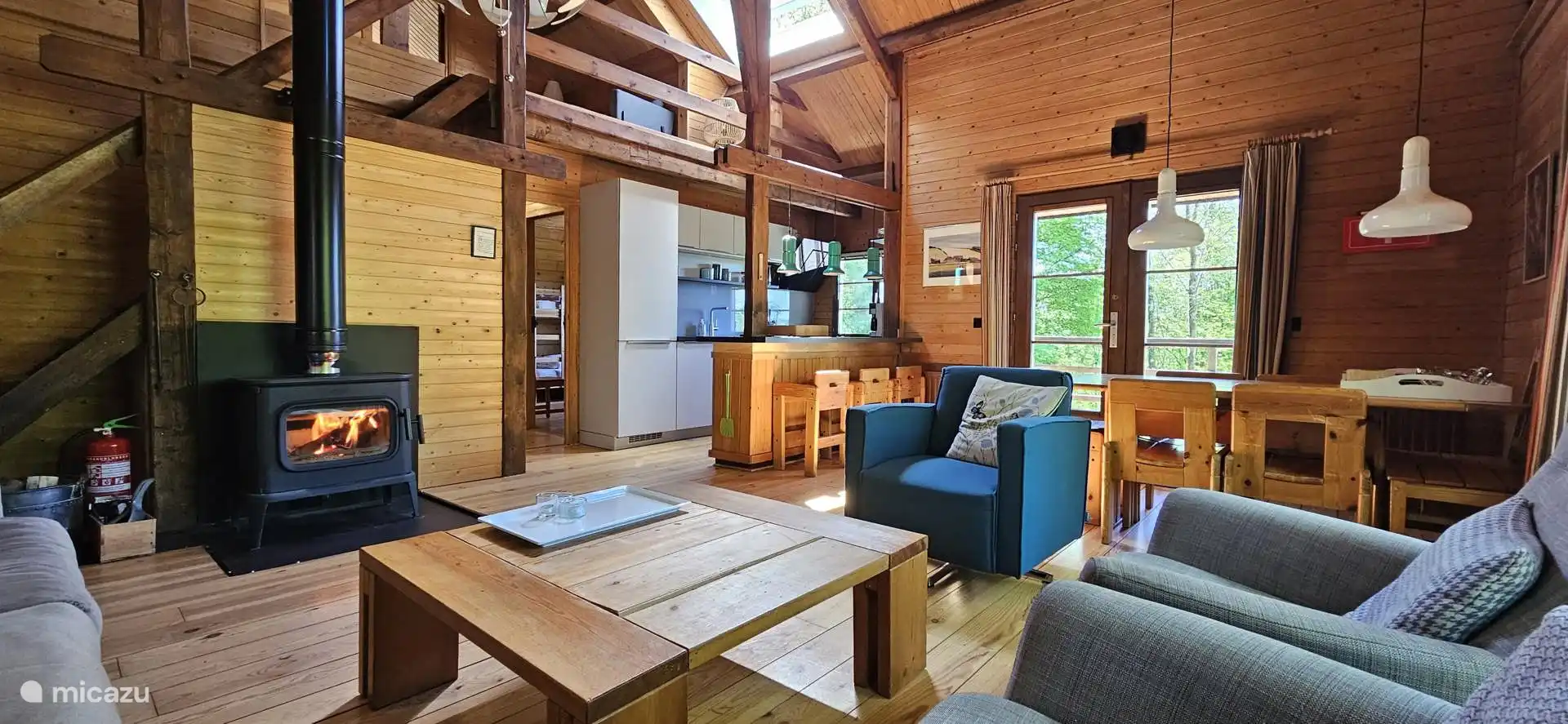 Gemütlicher Holzofen im Wohnzimmer mit viel Sonnenlicht