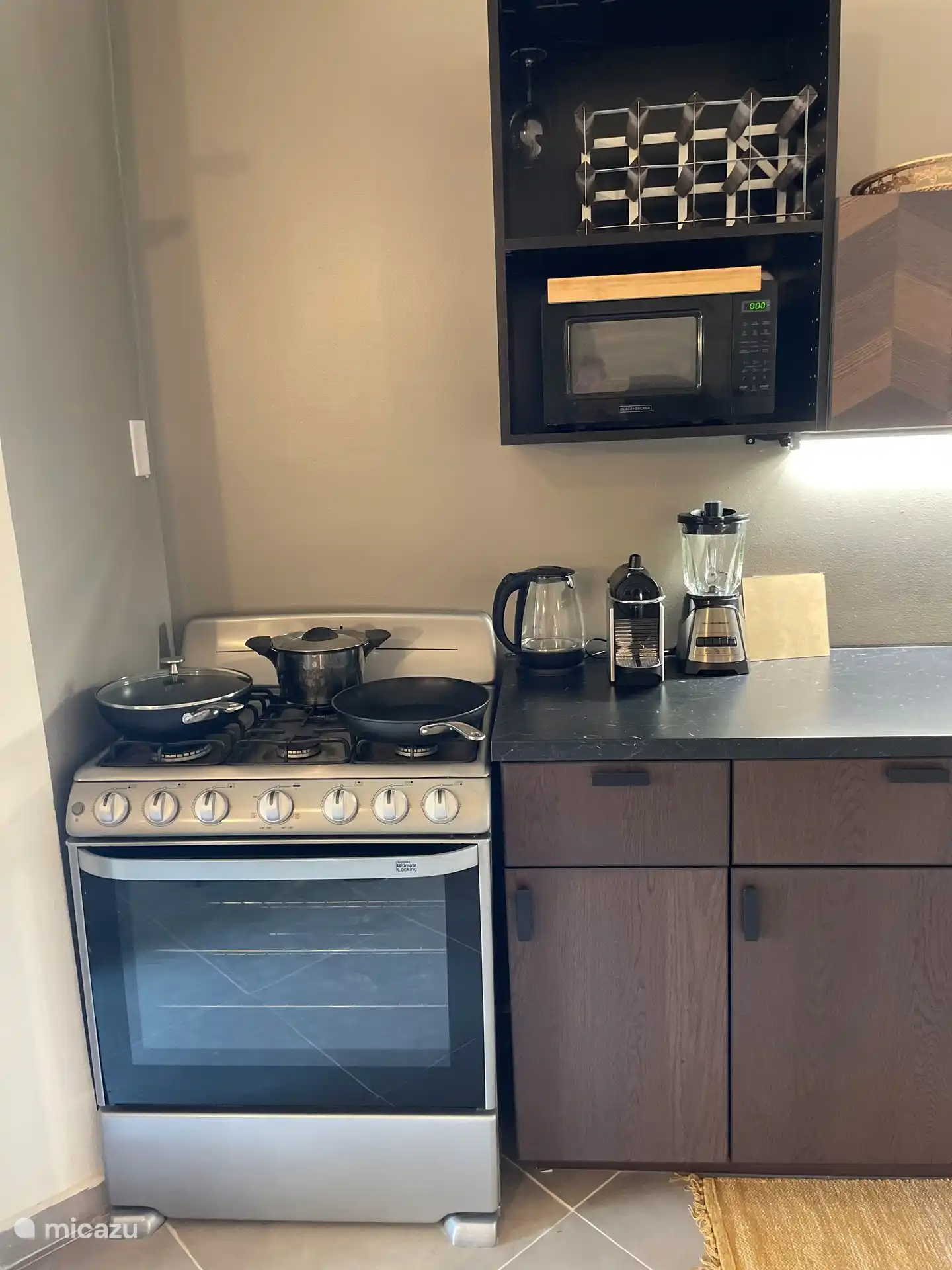 Cocina con microondas, horno, cocina a gas, hervidor, batidora y cafetera.