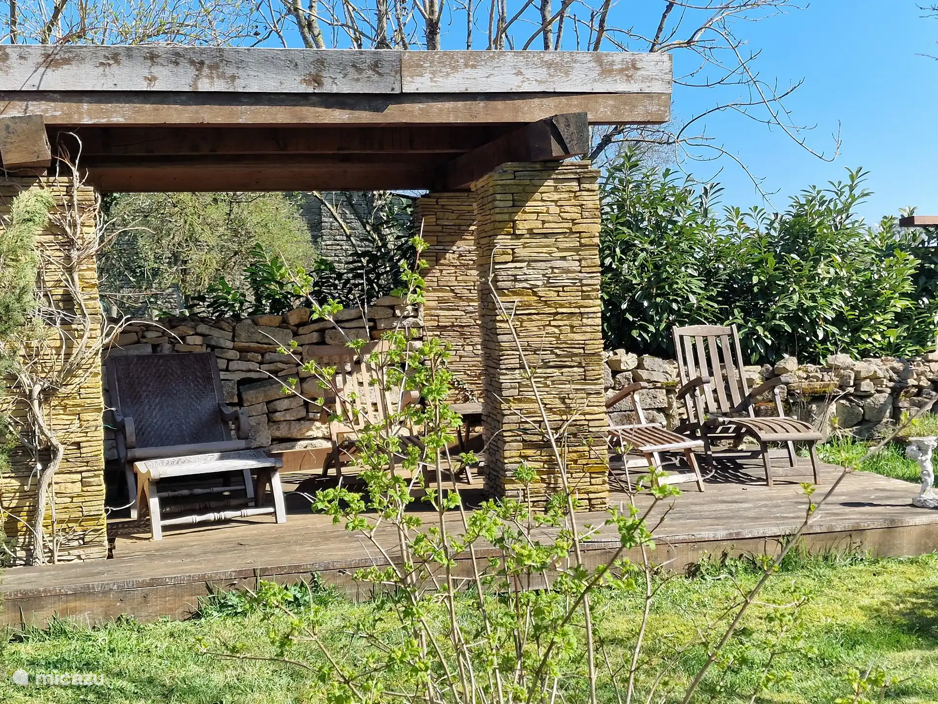 Sitzbereich im hinteren Teil des Gartens mit Liegestühlen (Kissen im Schuppen)