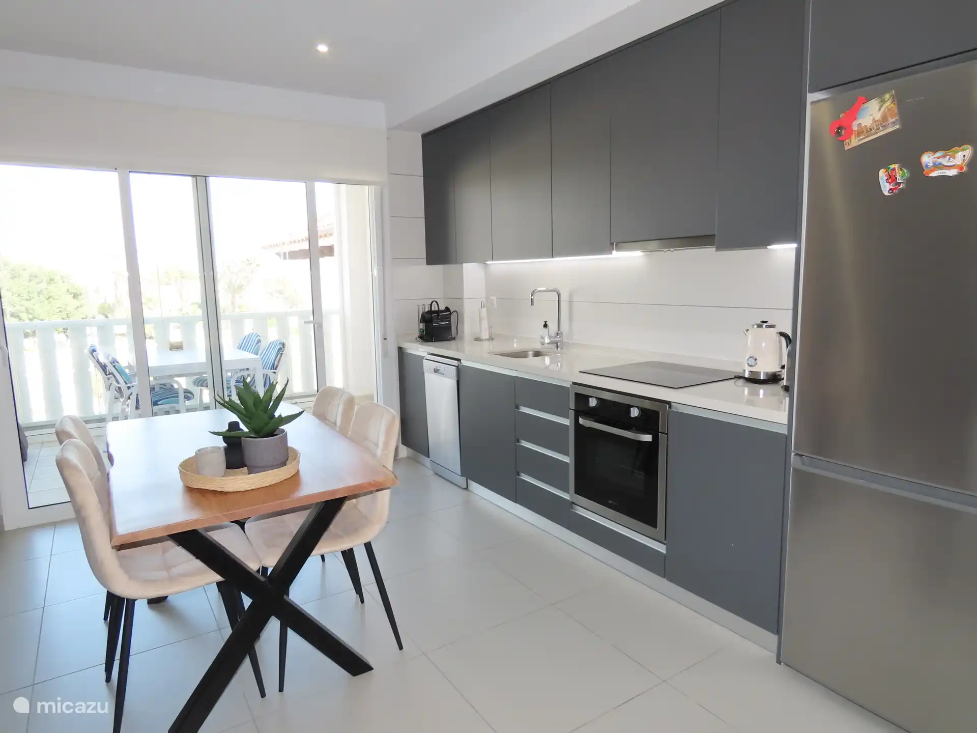 Cuisine moderne avec des salles à manger dans la cuisine et sur la terrasse (qui peut être fermée par un rideau de verre)