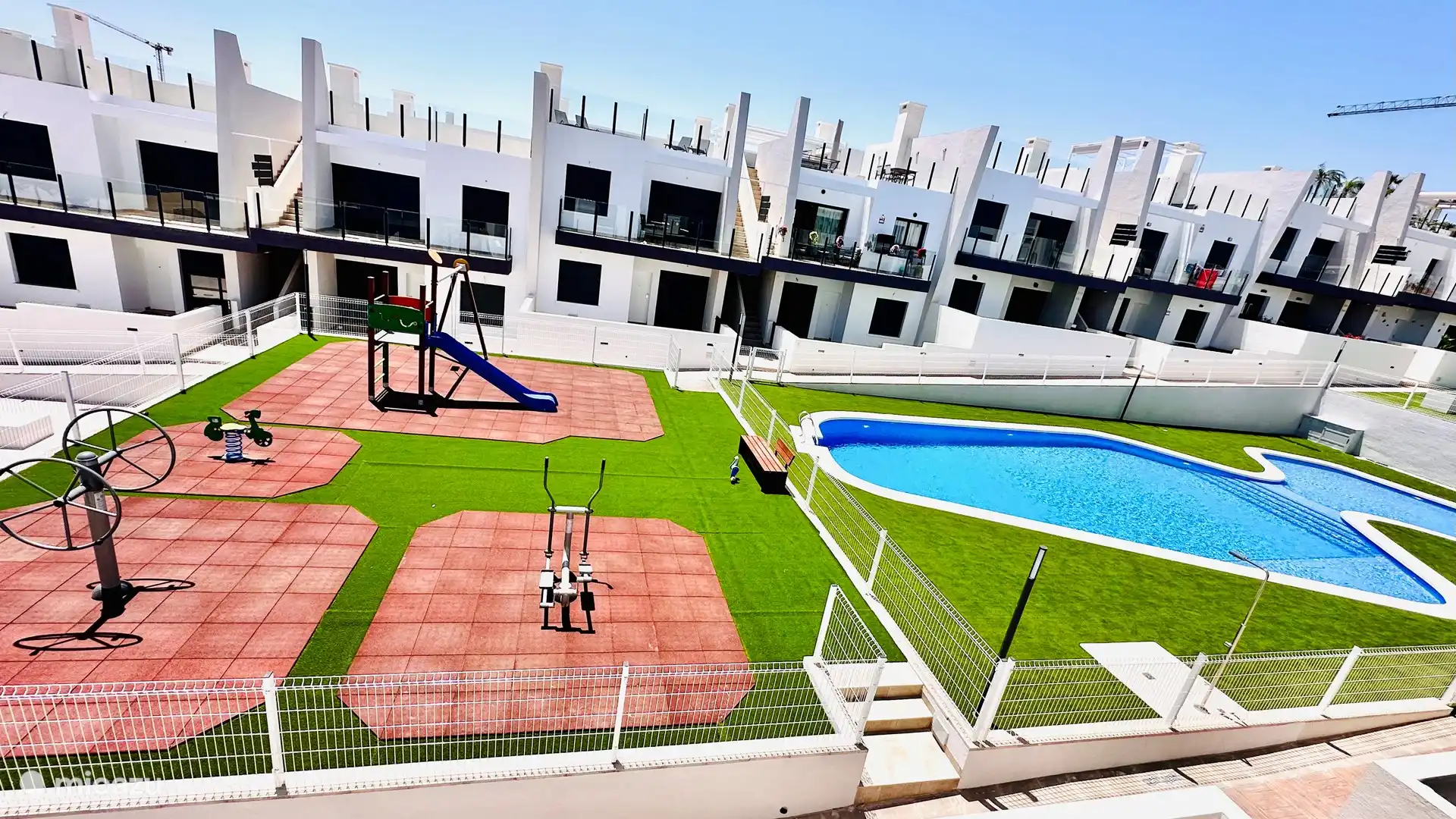 Gemeenschappelijk tuin met zwembad en speelapparaten