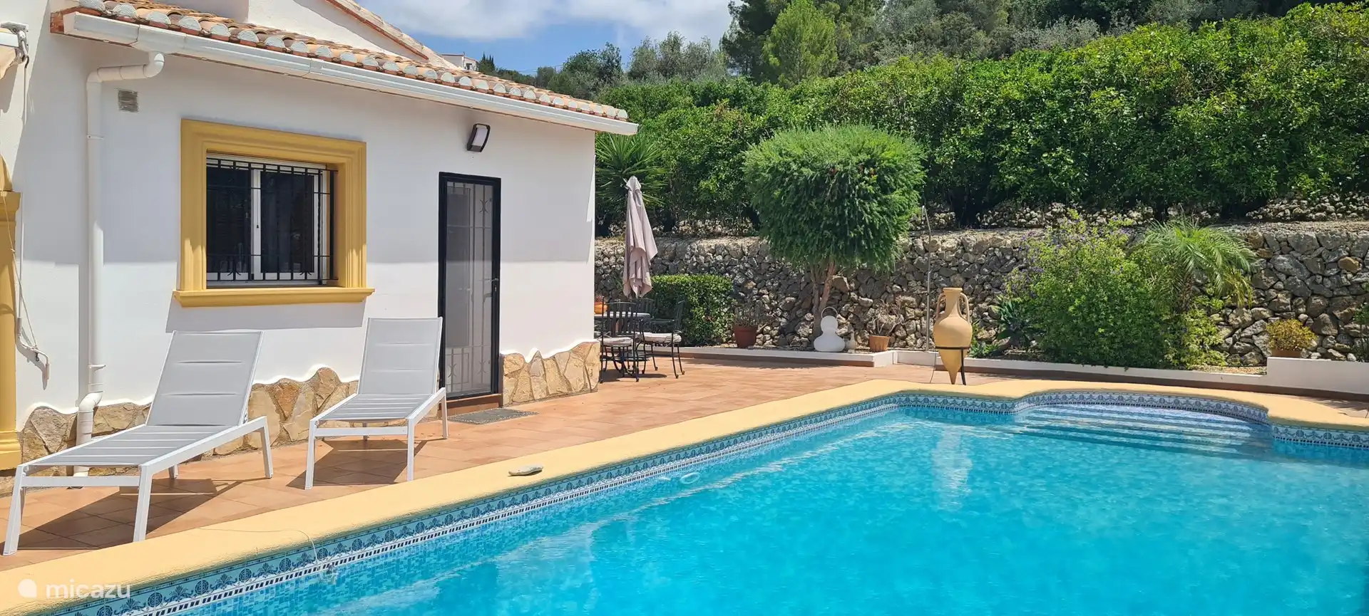 Sonnenliegen auf beiden Seiten des Pools