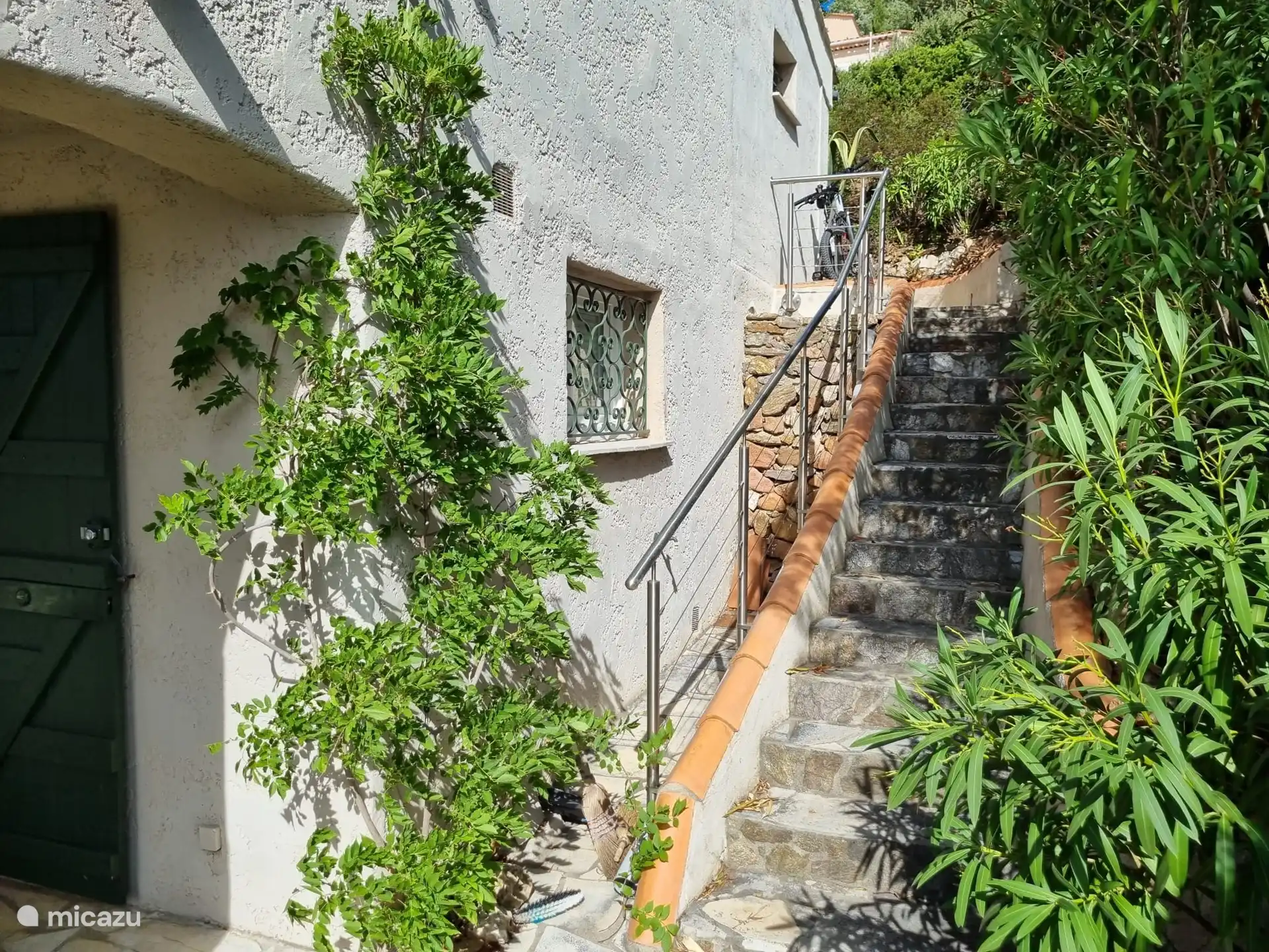 Vom Tor aus gelangt man, vorbei an Blumen im Sommer, über die Treppe in das Erdgeschoss des Hauses, wo sich auch der Eingang befindet. 