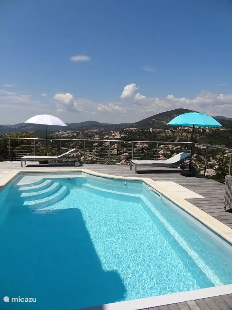 Der erfrischende Swimmingpool liegt auf der gleichen Ebene wie die Terrasse mit Sonnenliegen.