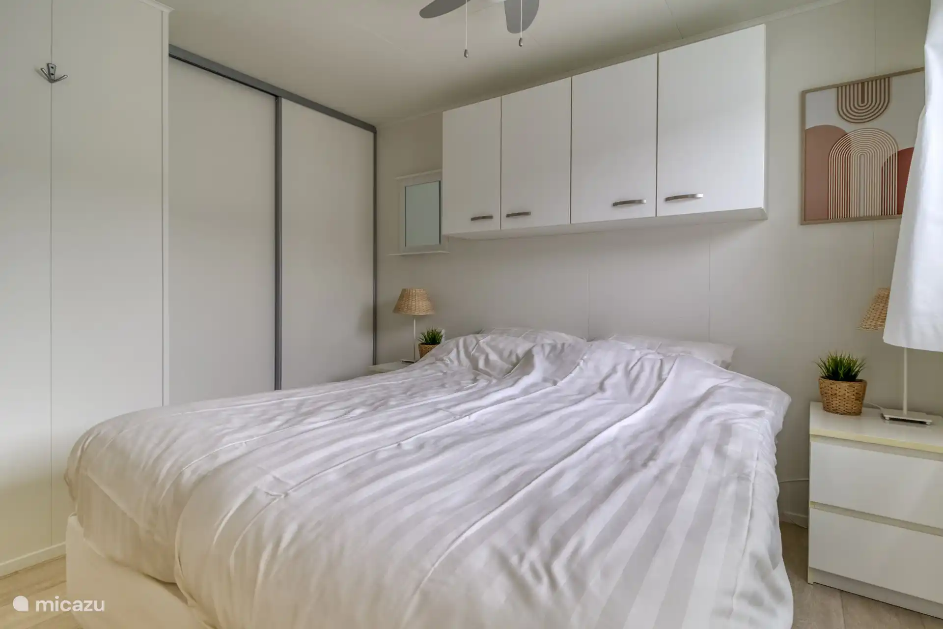 1e Slaapkamer met 2 eenpersoons boxsprings, televisie en kledingkast