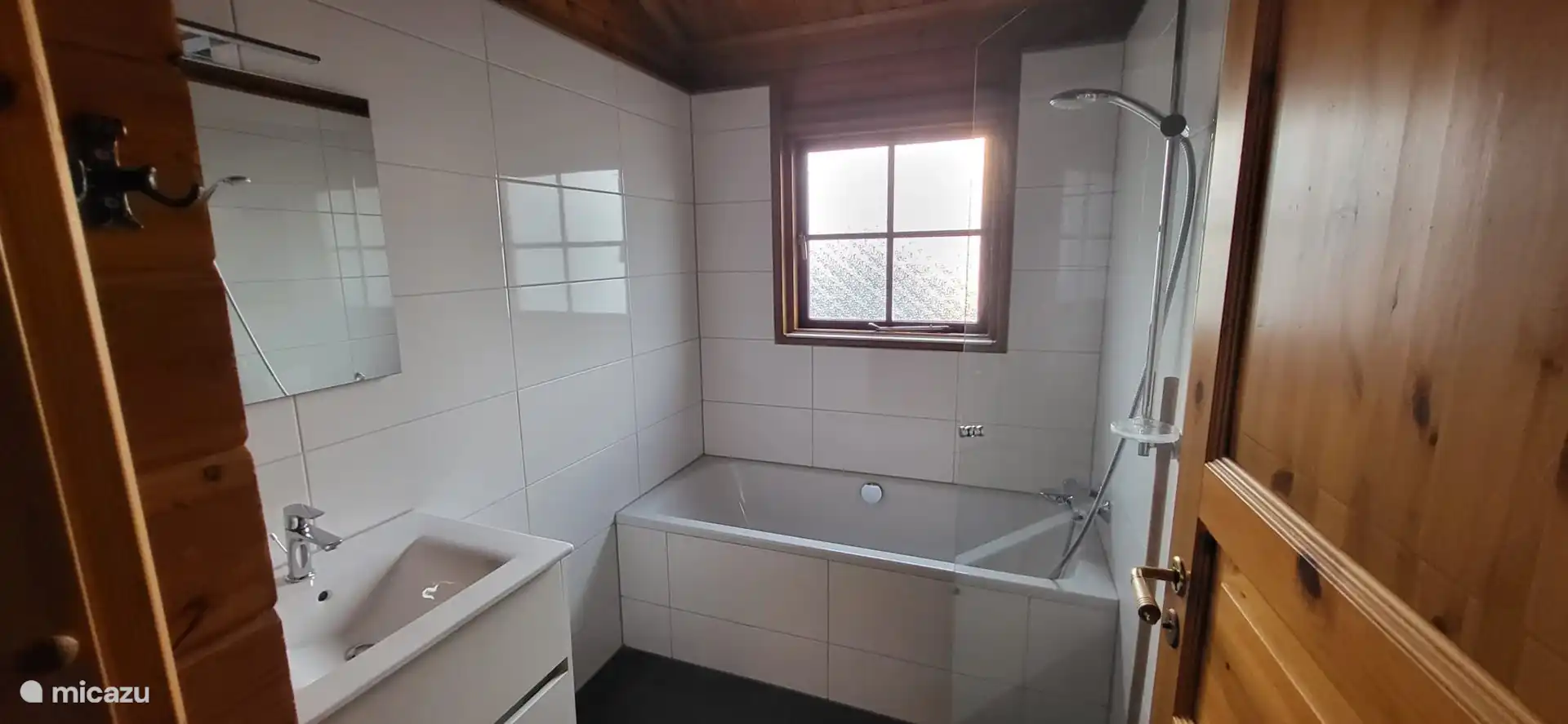 Badezimmer mit ebenerdiger Dusche, Badewanne und Waschbecken.