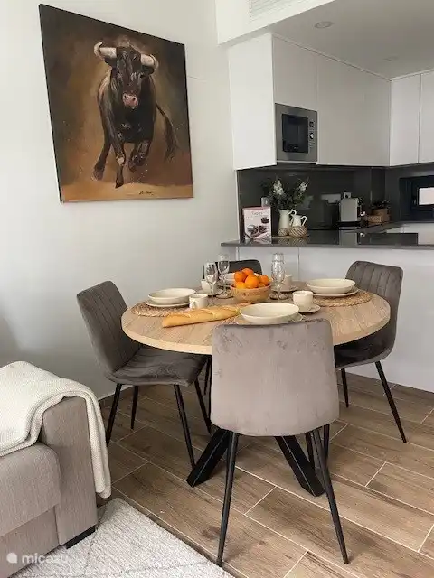 La table à manger ronde confortable est située dans le salon et est adjacente à la cuisine ouverte.