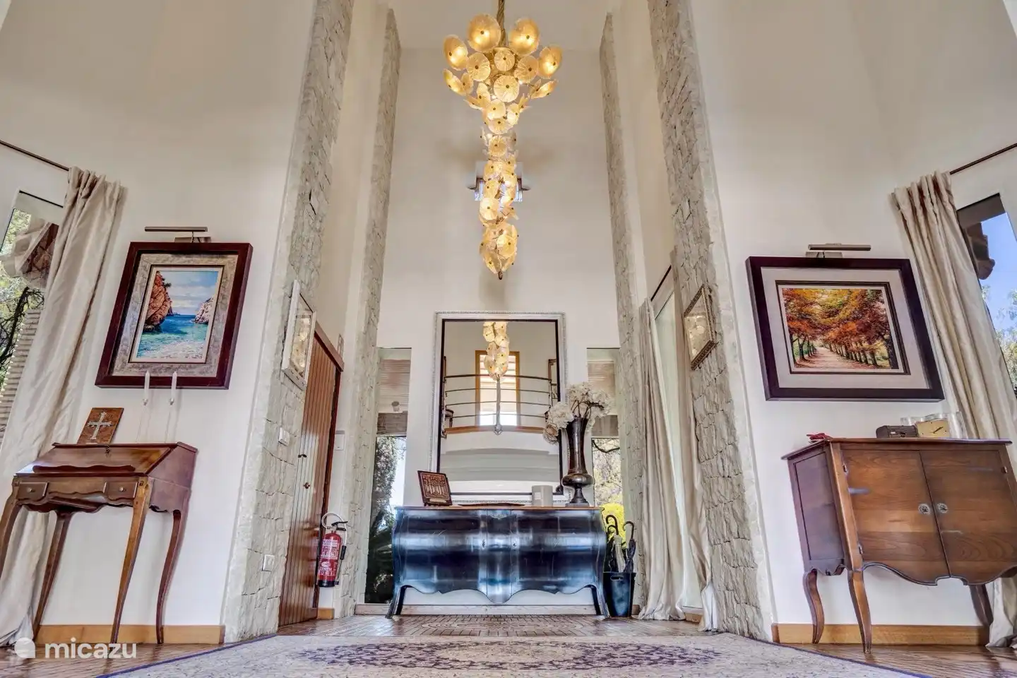 Amplio hall de entrada desde el que se accede por unas escaleras al primer piso donde se encuentran 4 de los 5 dormitorios.