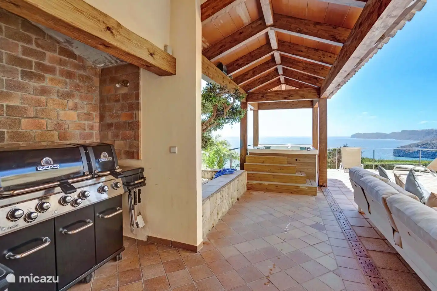 Una terraza cubierta con jacuzzi y barbacoa Broil King