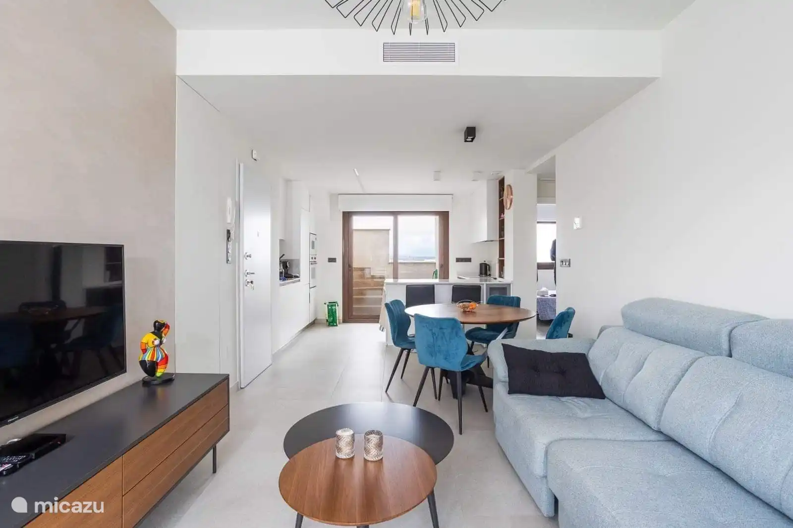 Offener Küchen-Wohnbereich mit angrenzender Terrasse mit Blick auf den Pool