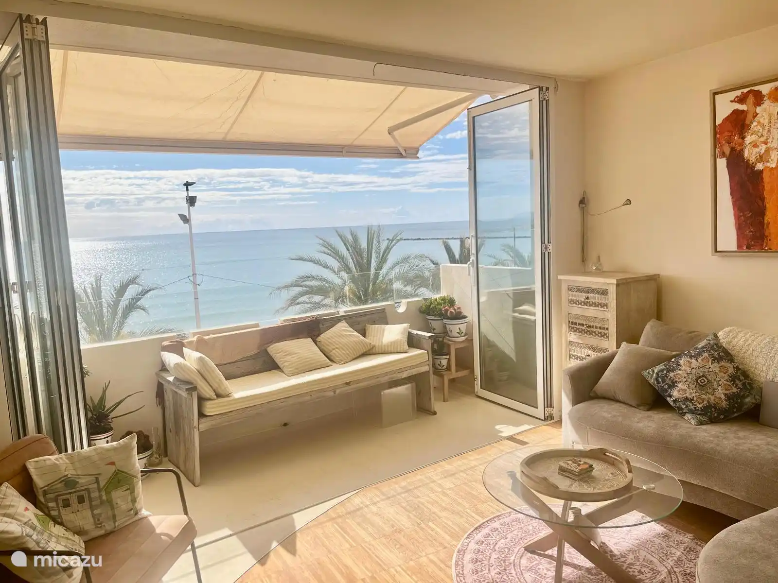 Sitzecke und Terrasse mit Blick auf das Meer, den Strand und die Strandpromenade.