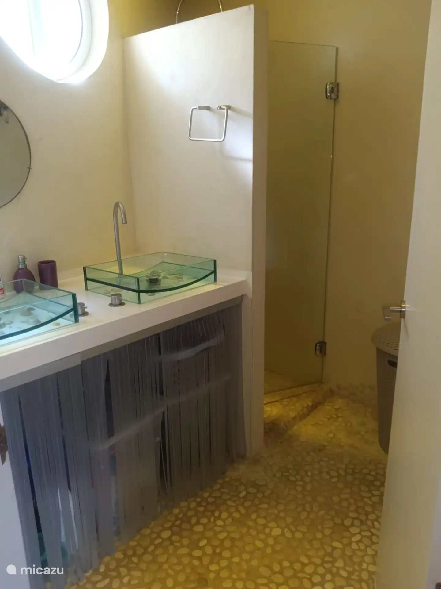 Runde Wände, runde Spiegel und Muscheln in den Waschbecken, Strandsteine auf dem Boden und in der Dusche.