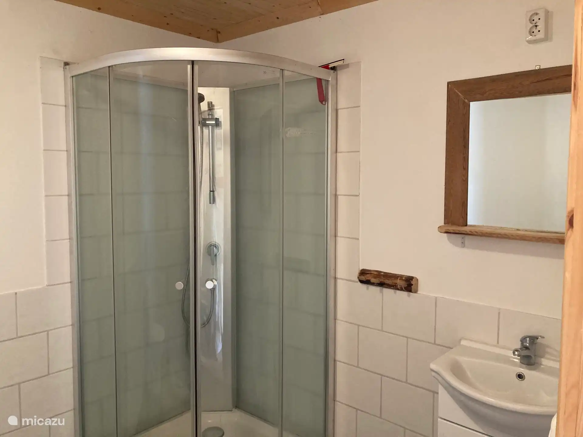 Salle de bain avec cabine de douche et lavabo.