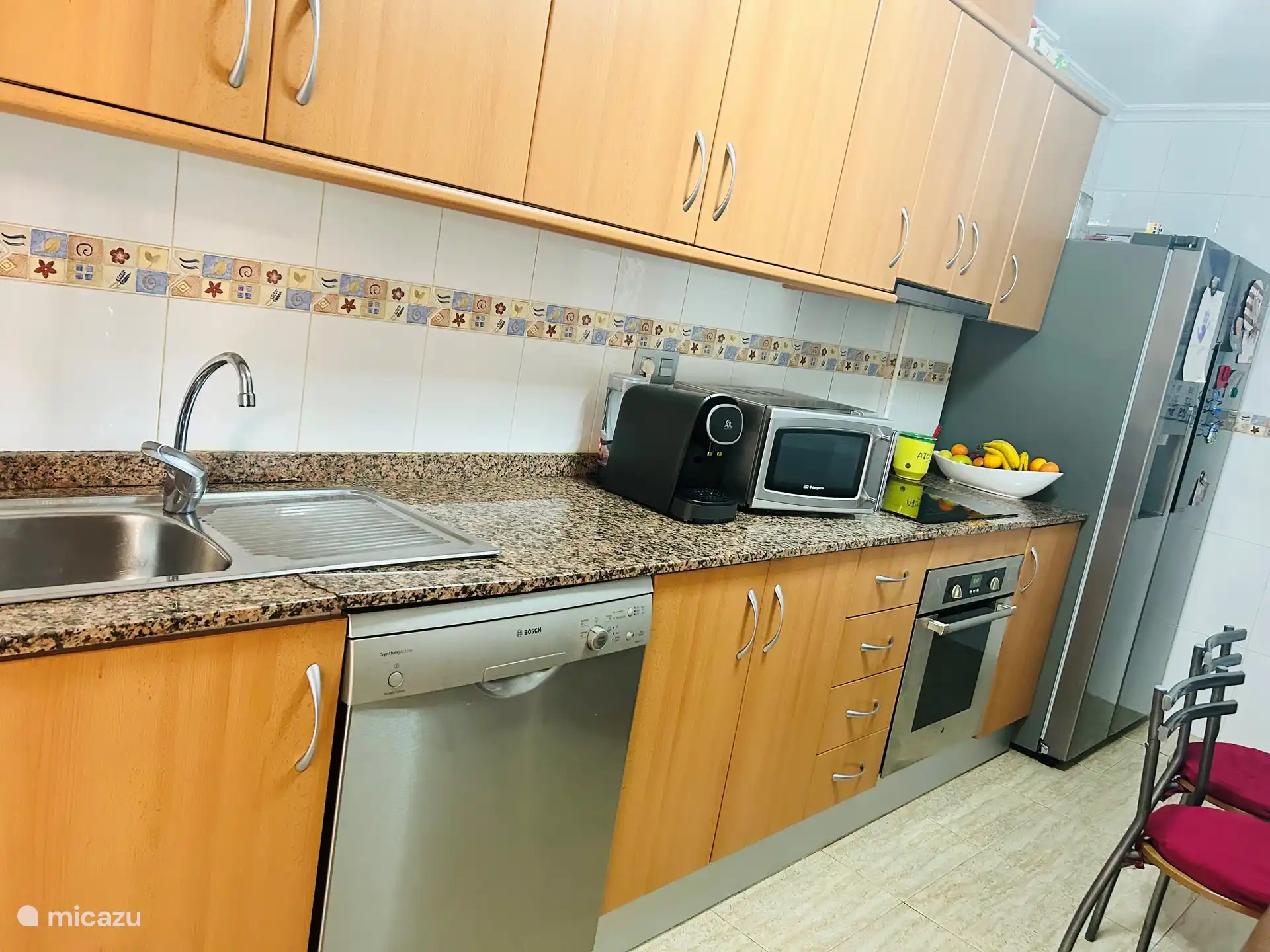 Keuken met Amerikaanse koelkast met water- en ijsdispenser, spoelbak, magnetron spoelbak en vaatwasser 