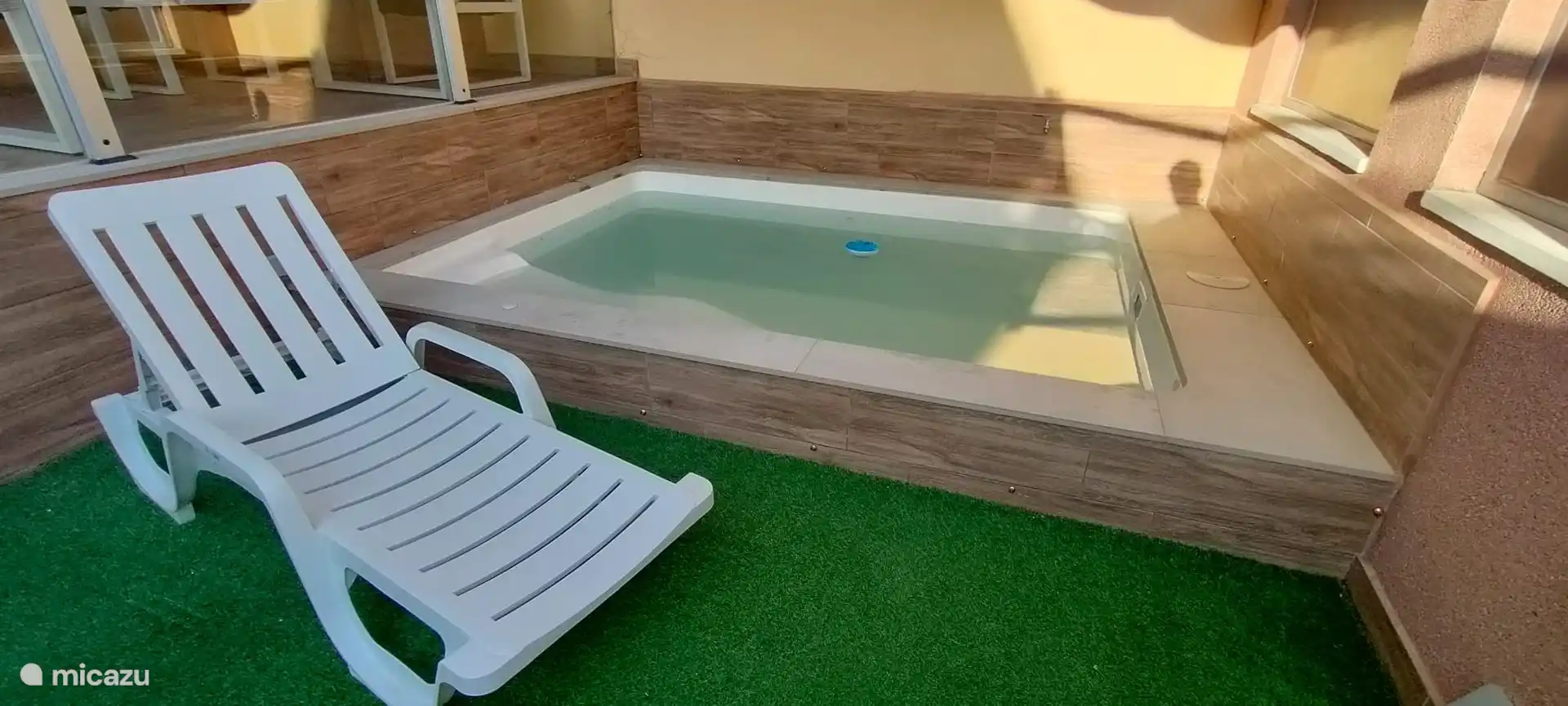 Zwembad en tuin met ligstoelen 