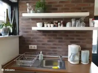 Küche mit Kaffeemaschine (Filter und Senseo), Wasserkocher, Zwei-Flammen-Induktionskochfeld, Kühlschrank, Backofen, Milchaufschäumer. 