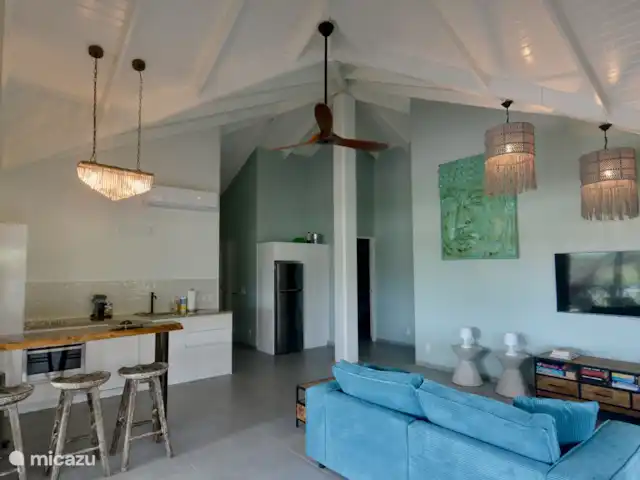 villa huren in Curaçao, Curacao-Midden, Blue Bay – The Best Blue Bay Beach Villa De woonkamer met volledig ingerichte keuken met bar, zithoek met smart tv en airconditioning